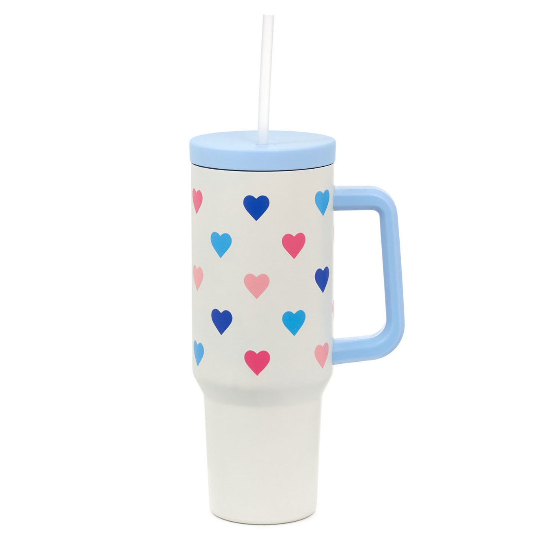white insulated tumbler with straw, blue cap and handle, and multi-colored heart design