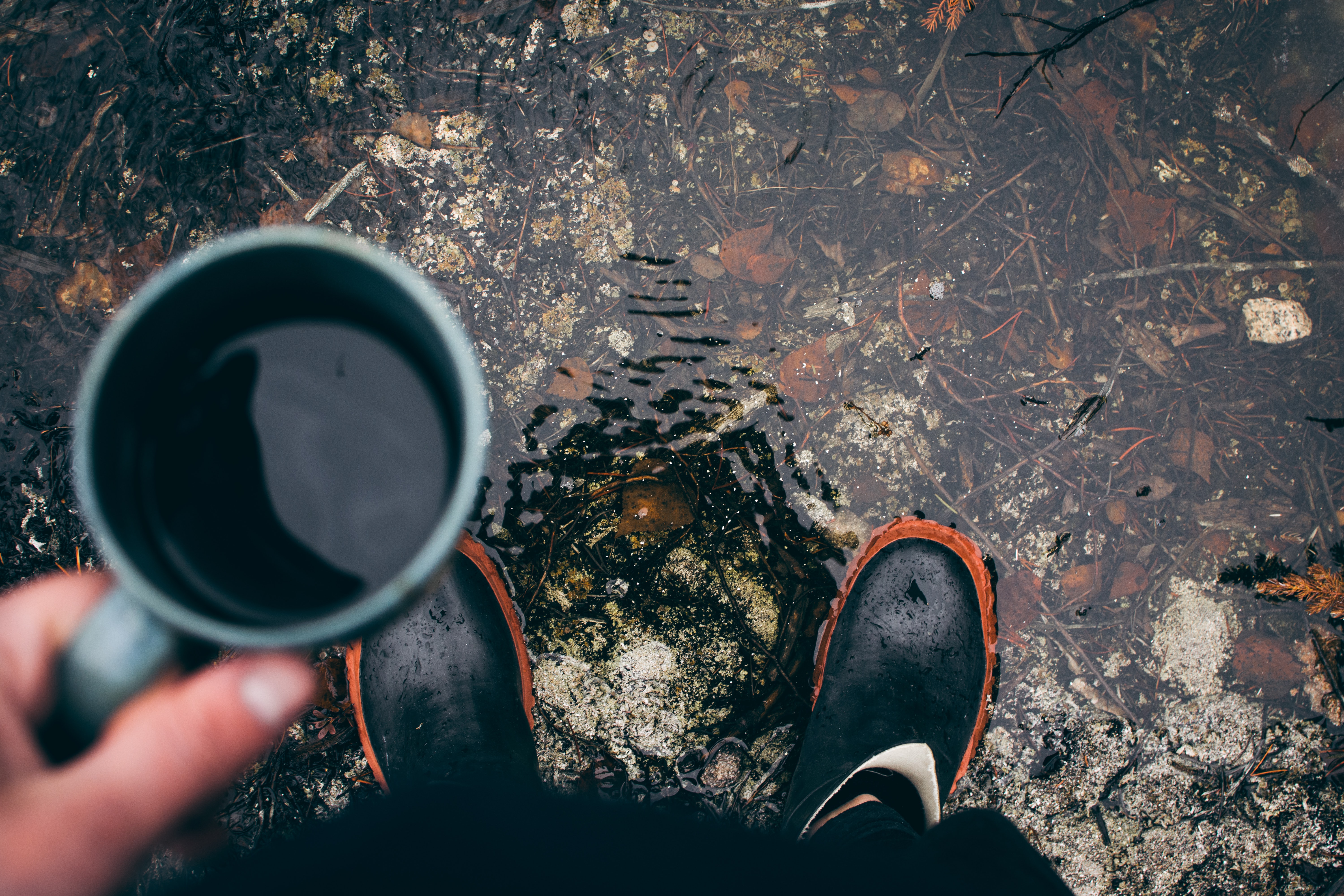 person holding coffee mug outdoors