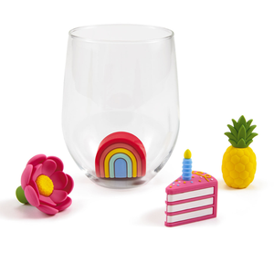clear stemless wine glass with four 3D insertable decoration: a flower, a rainbow, a slice of cake, and a pineapple