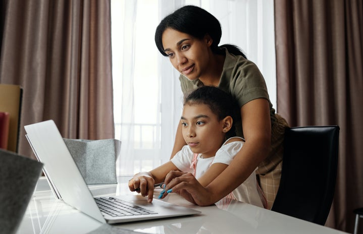 Woman and her daughter looking at a computer.