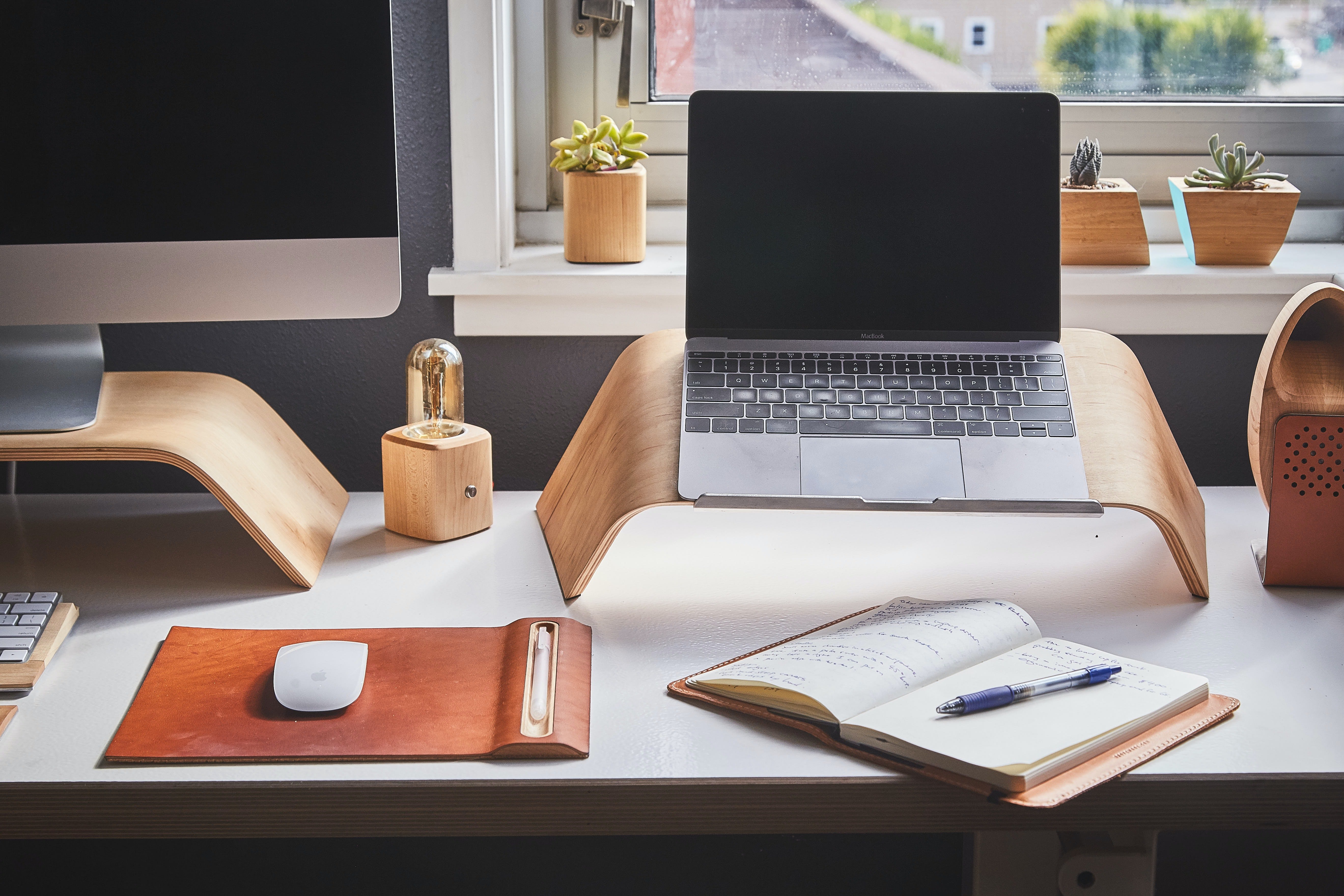 Computer desktop and laptop on wooden stands on desk