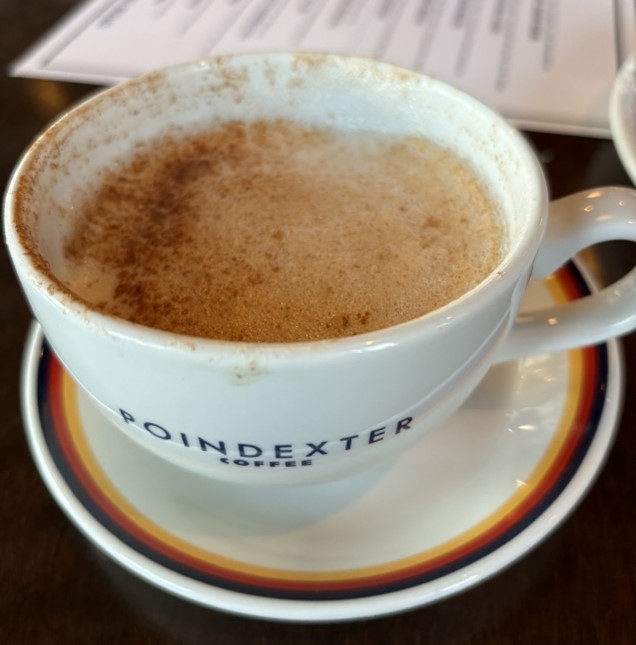 Close up of frothy chai latte with menu in the background