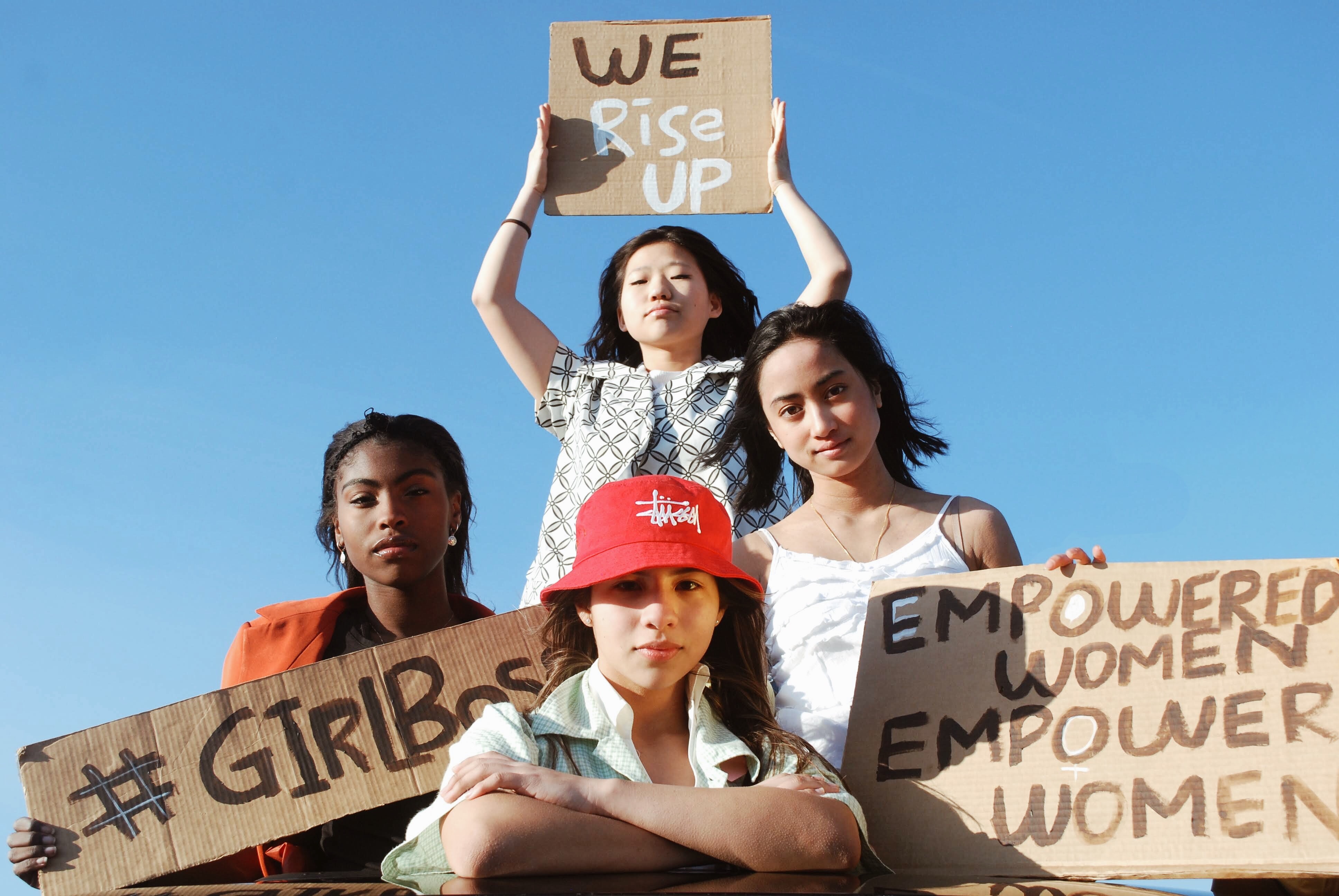 group of girls holding cardboard signs with empowering statements