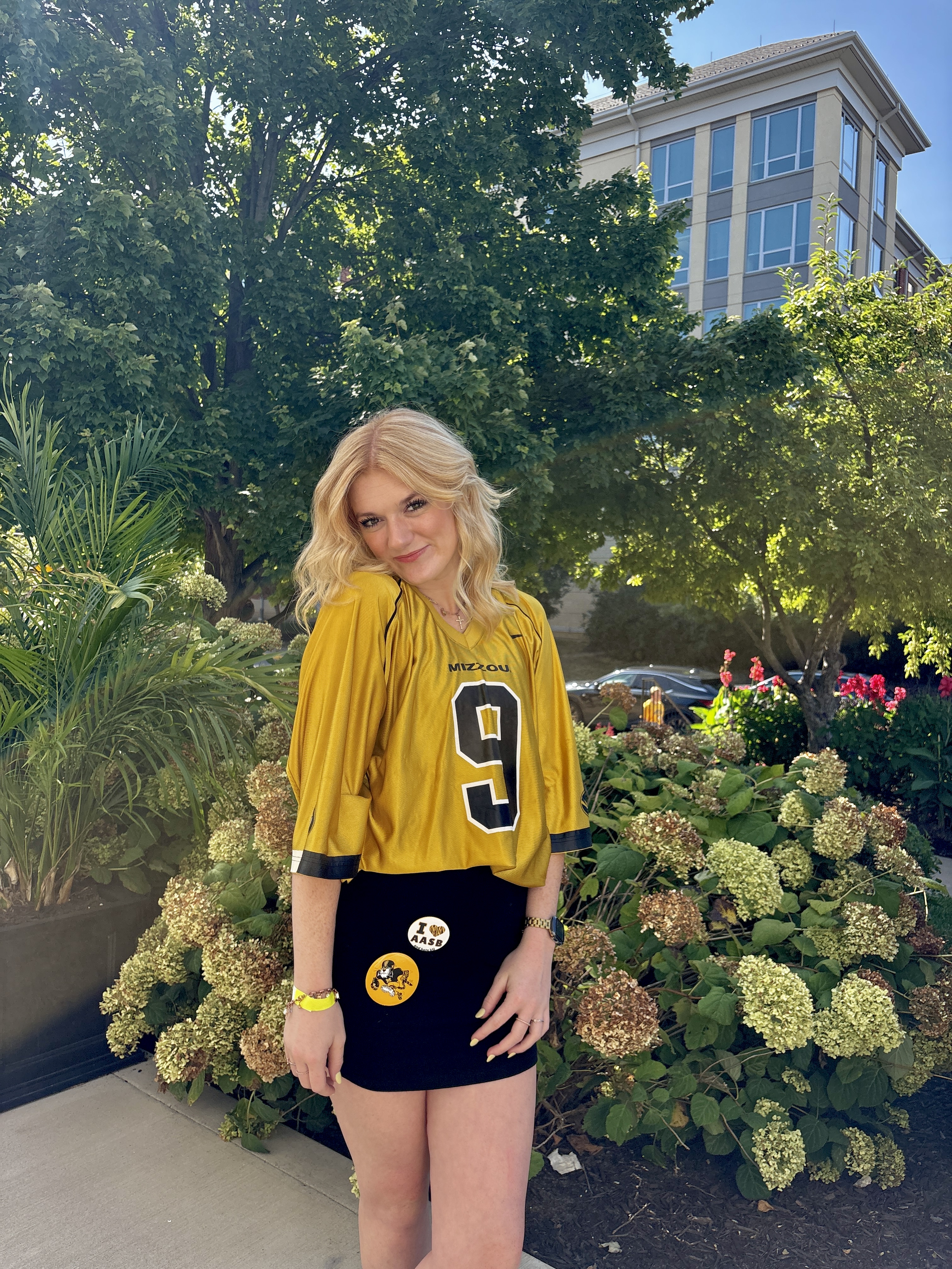 A girl in a yellow jersey posing for gameday
