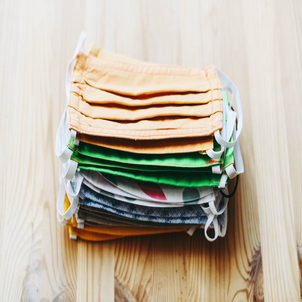 Stack of cotton face masks on wooden table.