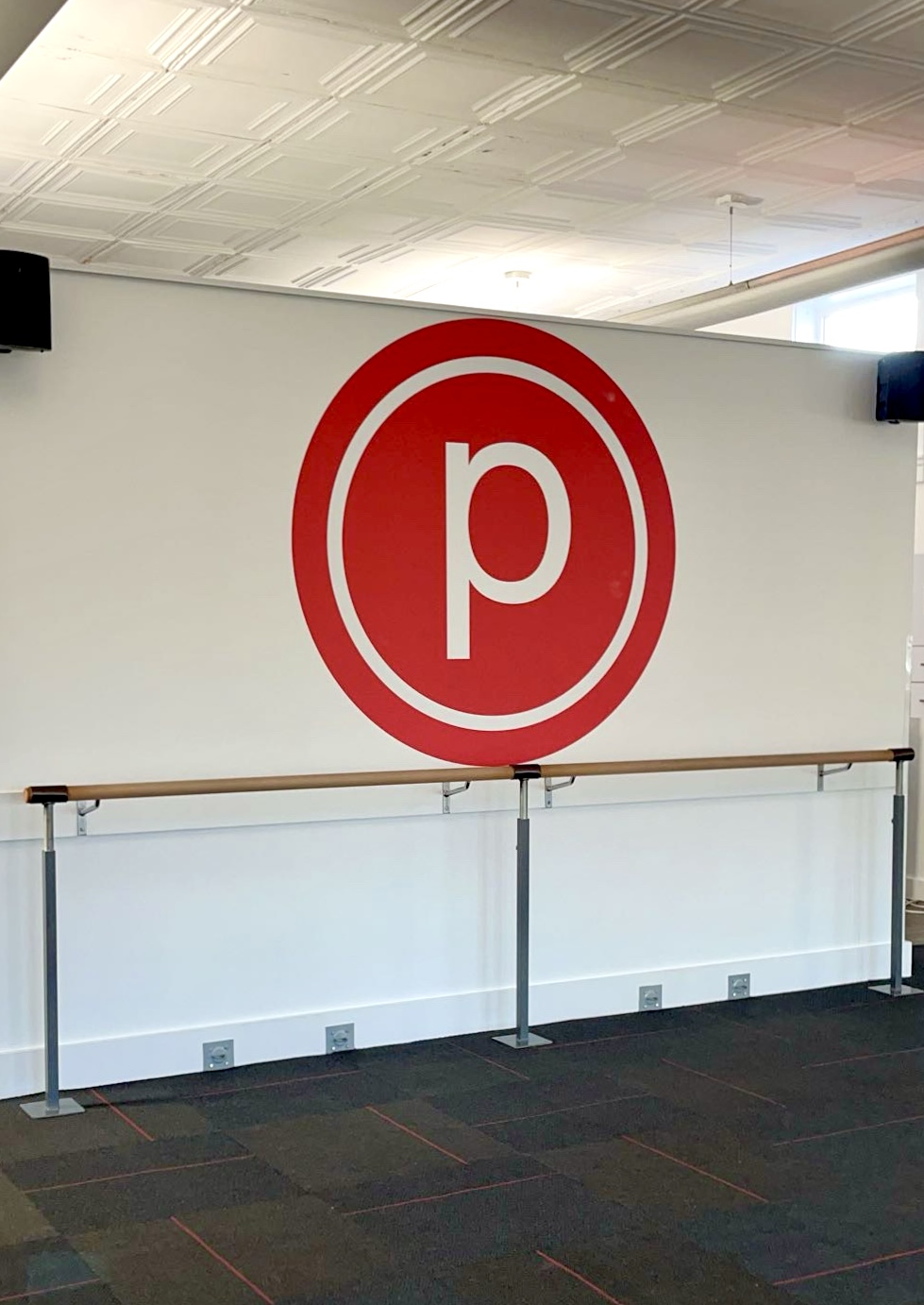 Pure Barre Logo, red circle with “P”, in barre studio
