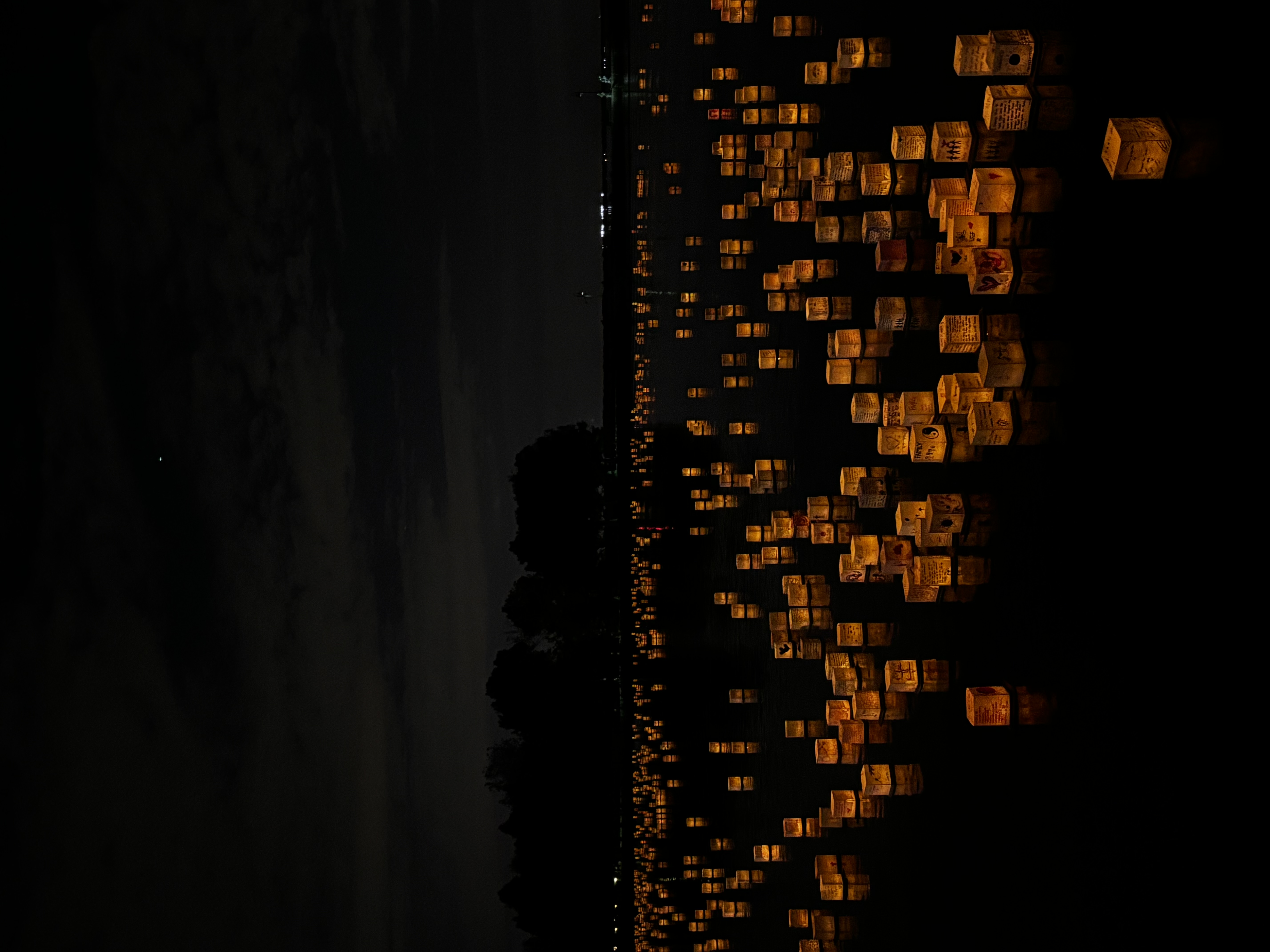 lanterns floating in a lake at night