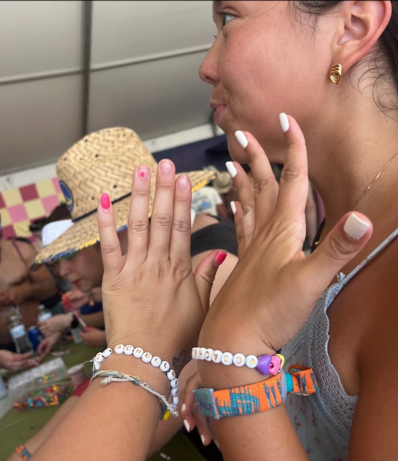 Two girls making beaded bracelets