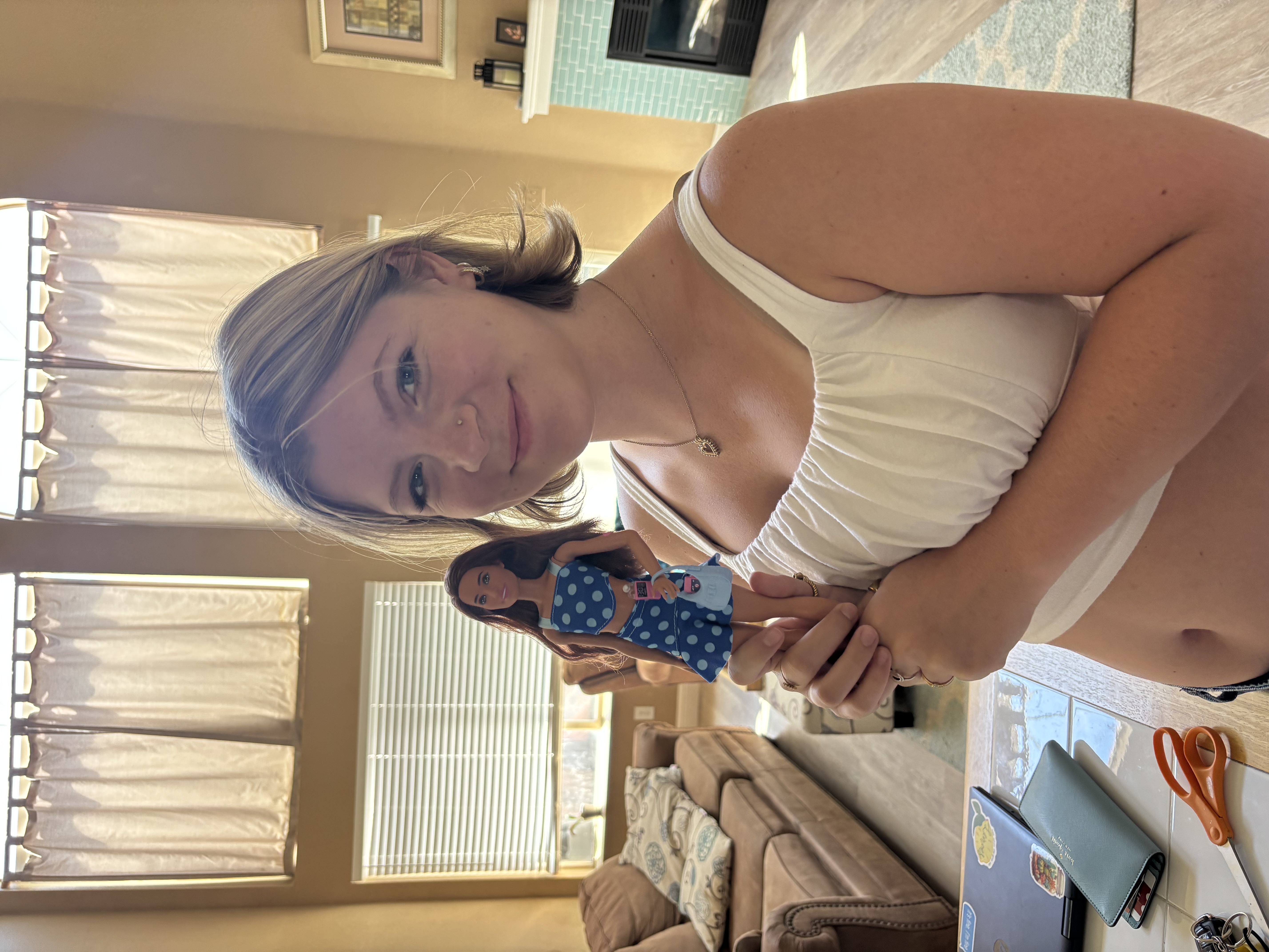 Teen holding Barbie smiling at camera