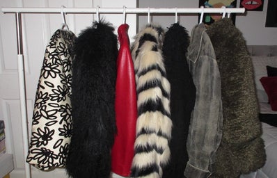 Clothing rack with six coats hanging from it.