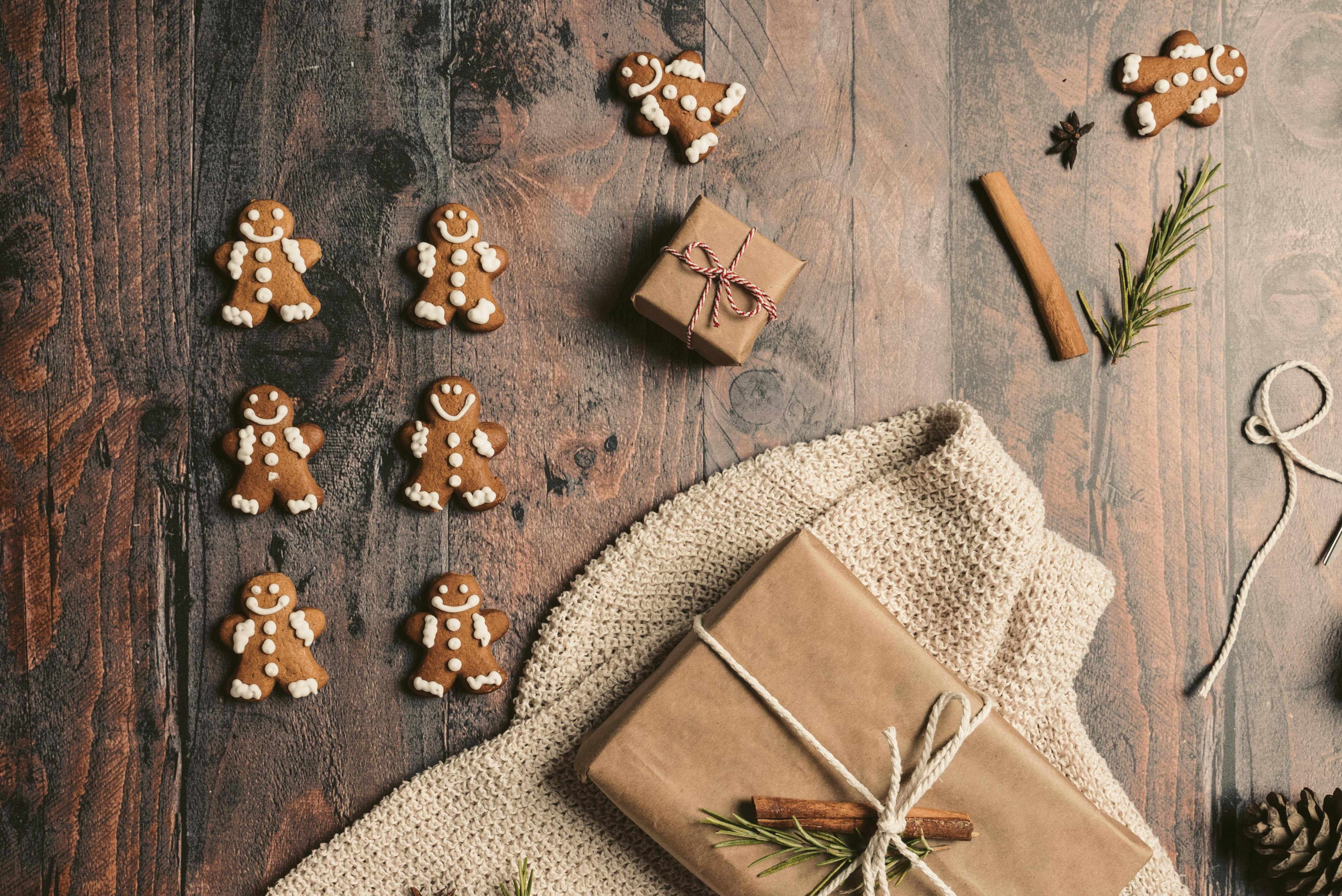 wooden background with gifts and gingerbread men on top