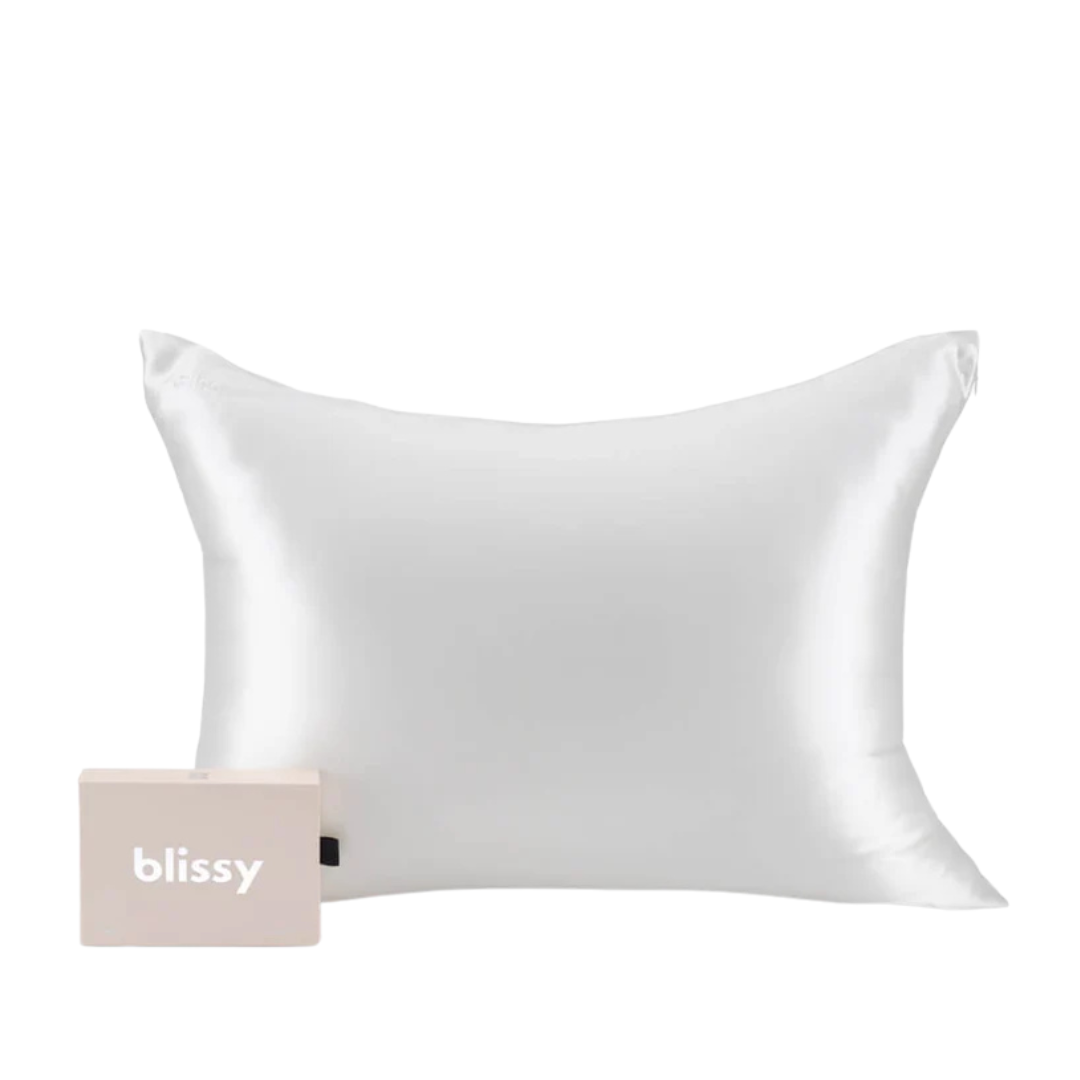 White silk pillow with a soft sheen placed next to a beige box labeled \