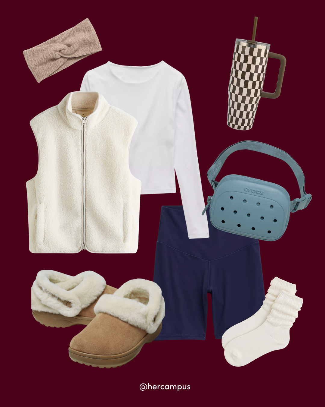 Flat-lay outfit of cozy campus essentials: cream fleece vest and slippers, white shirt, navy leggings, headband, blue bag, tumbler cup, and socks on burgundy.