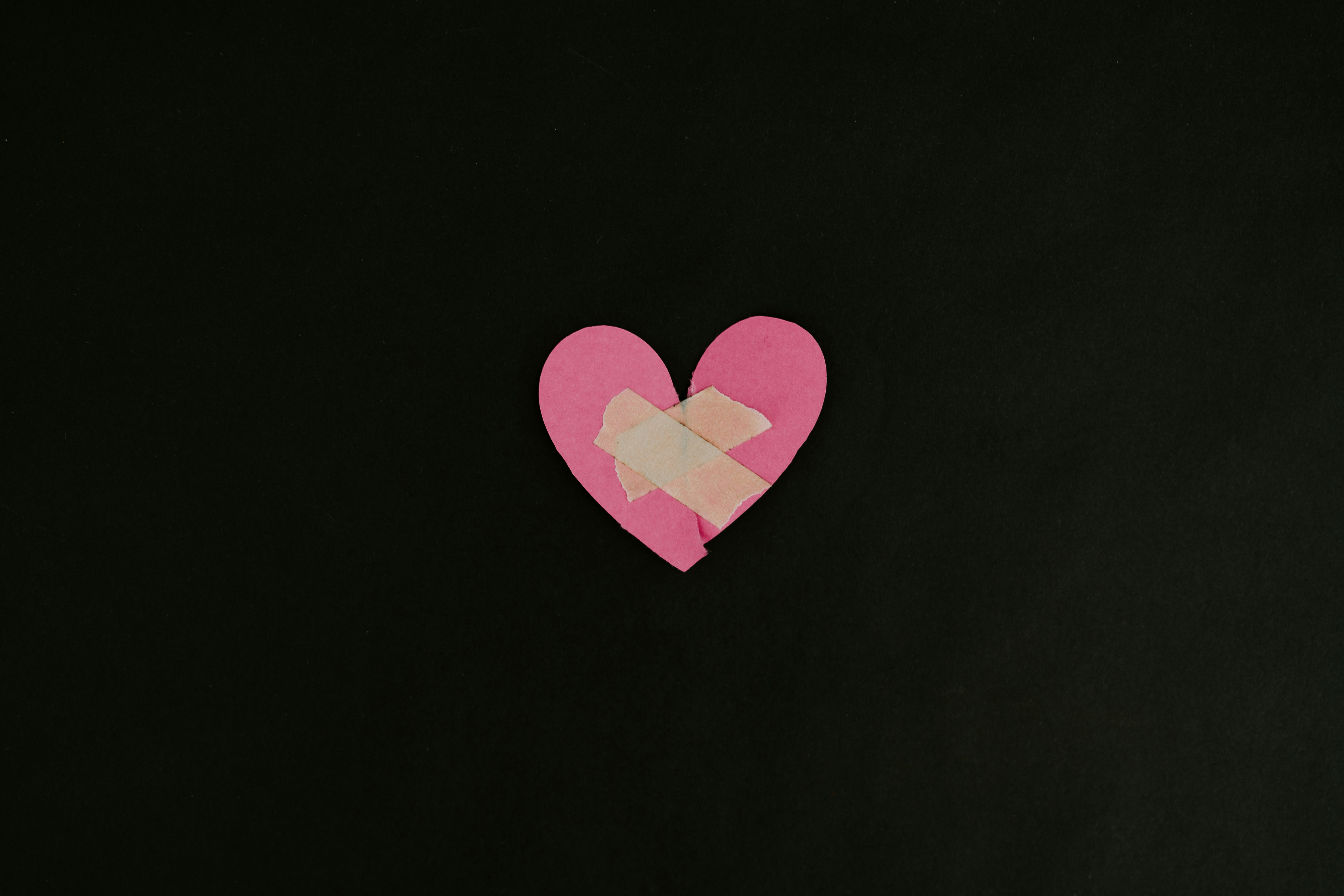 torn up pink heart put together by tape