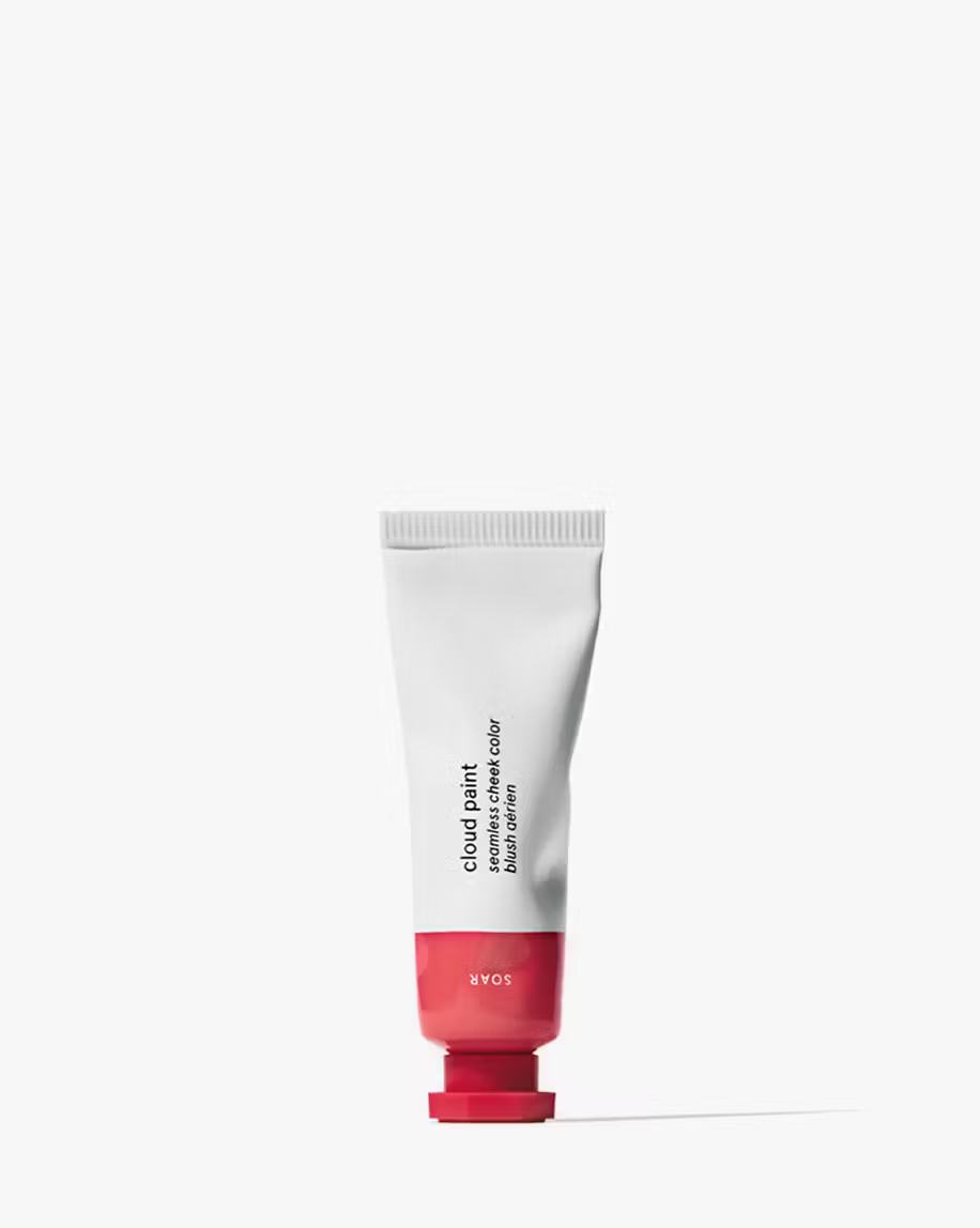Glossier cloud paint blush tube in color soar which is a bright pink, pink and white tube with a white background