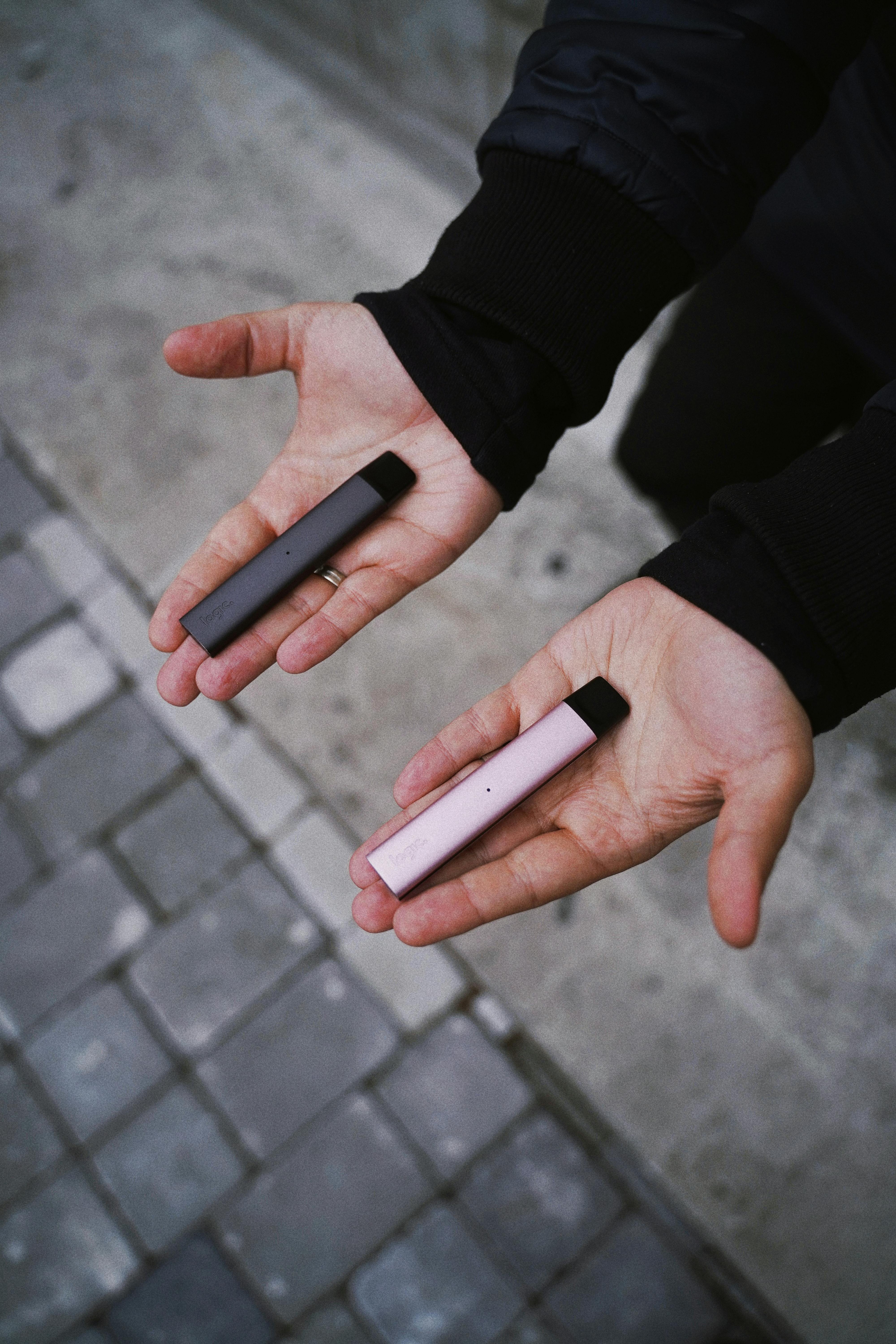 Vapes held in hands.