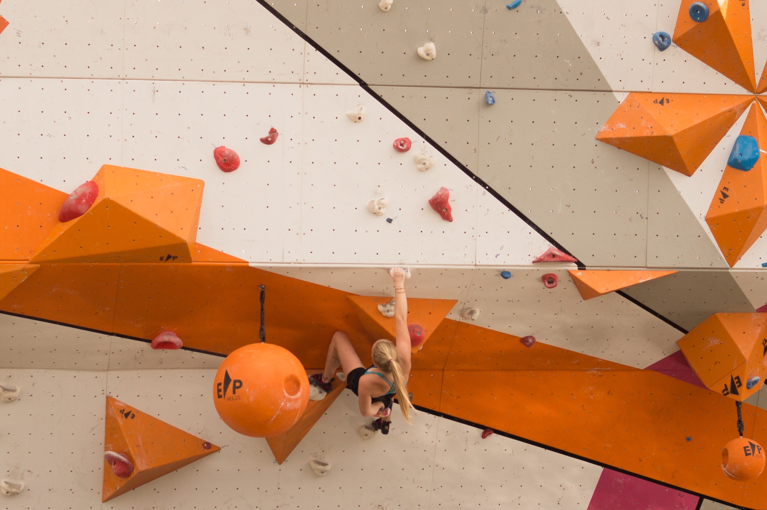 her campus western, woman bouldering on indoor wall