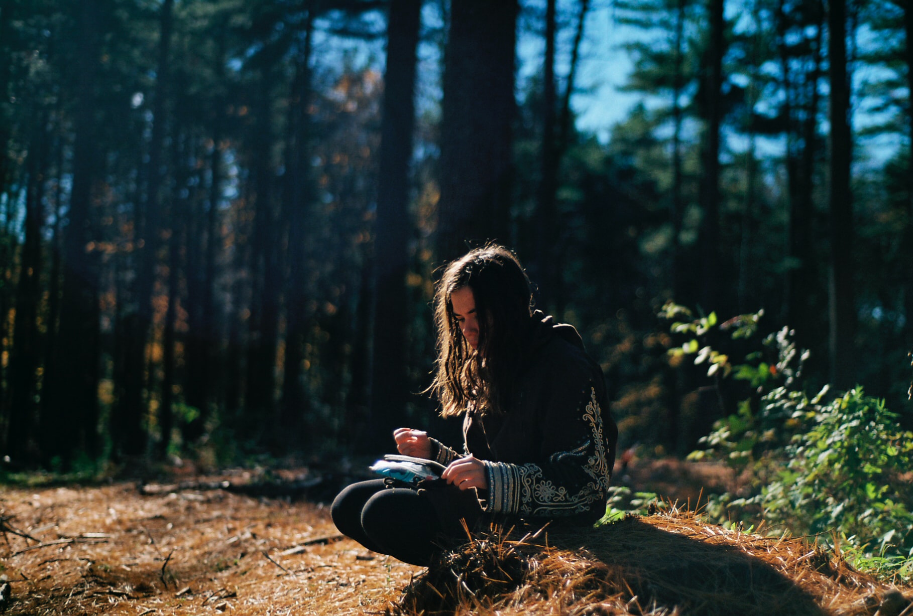 woman sitting in the forest writing