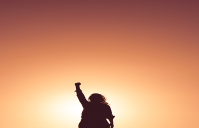 Silhouette of woman holding up fist