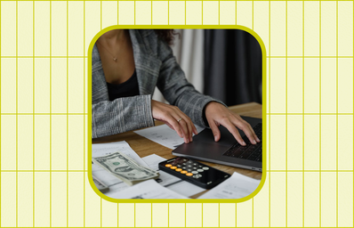 woman calculating with laptop, money, and forms