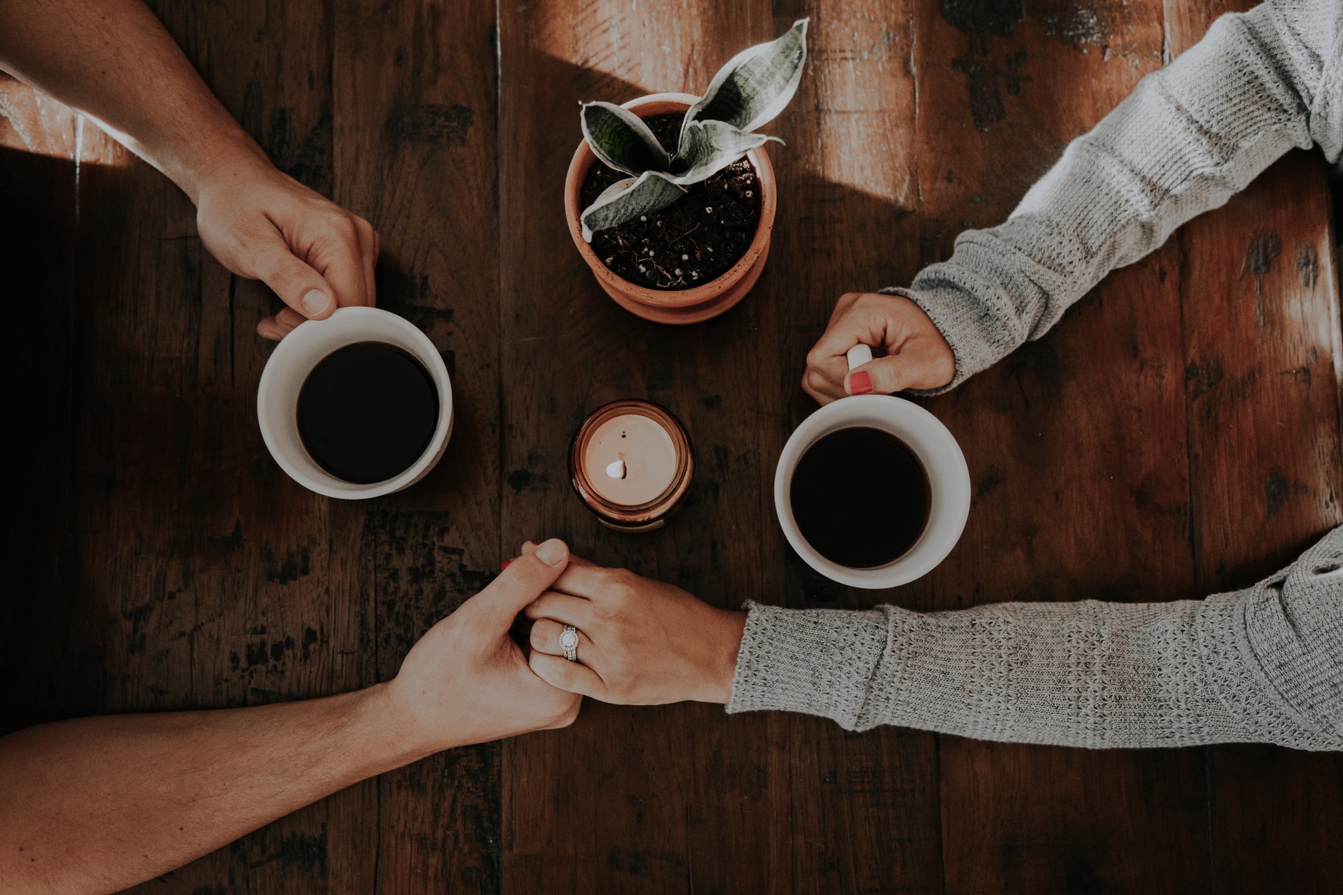 Couple holding hands over coffee by Unsplash?width=698&height=466&fit=crop&auto=webp&dpr=4