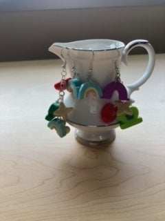 A creamer holding my original earrings I made using 3D modeling and 3D printing.