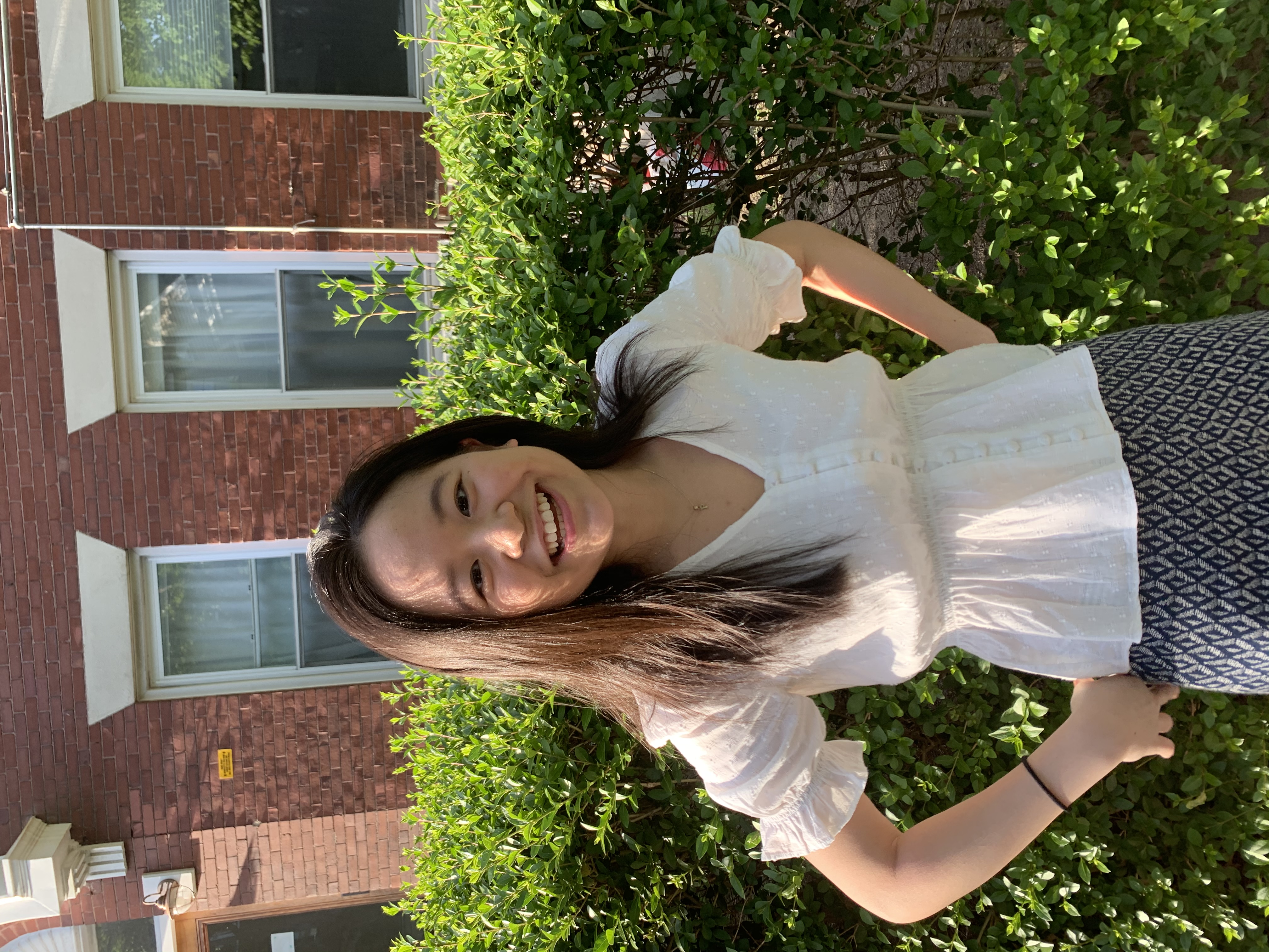 woman smiling in front of hedge