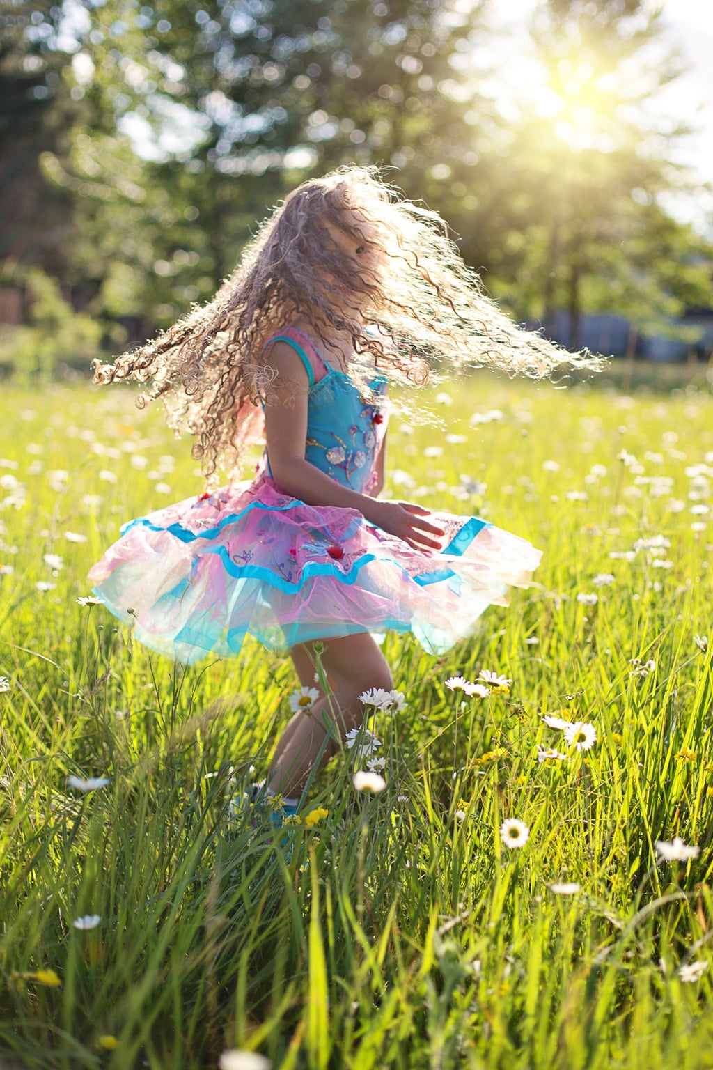 young girl spinning in field