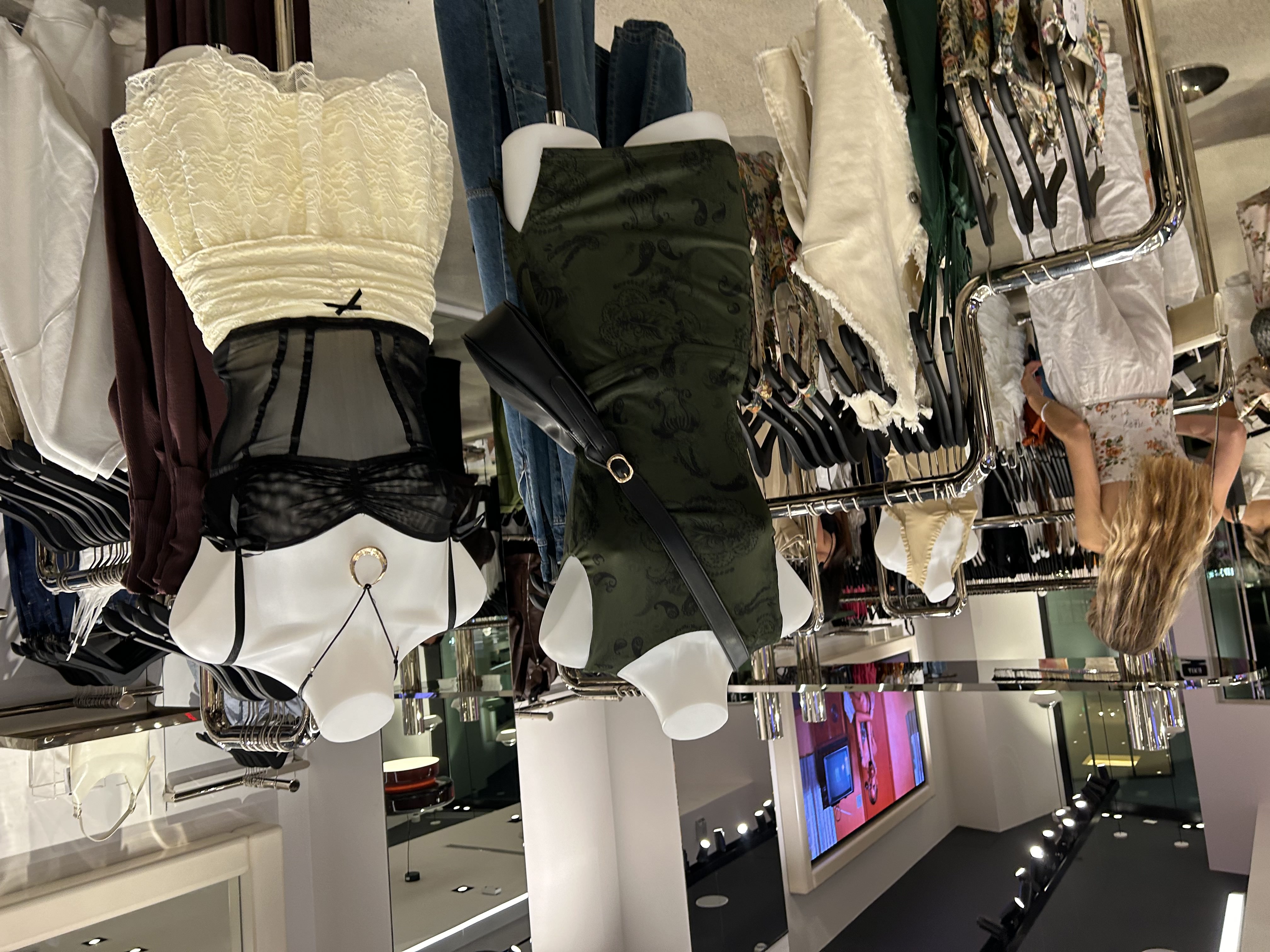 Two mannequins stand in a store of women\'s clothing.