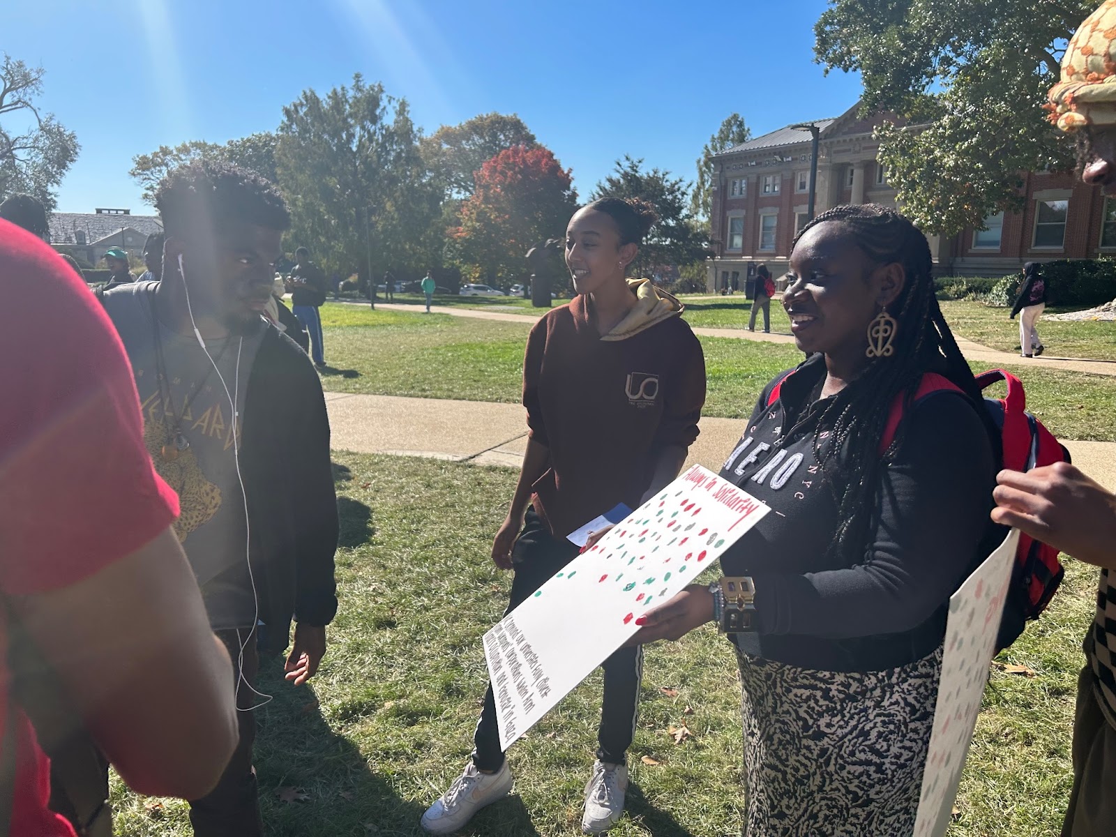 Attendees stamp a black, white or green fingerprint on signs that read “Always in solidarity” and “Always remembering”.