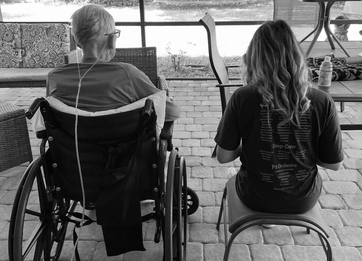 girl and grandfather sitting on patio