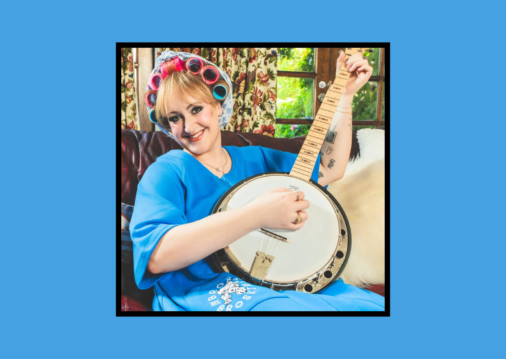 this is brittany broski holding a banjo wearing blue and hair rollers
