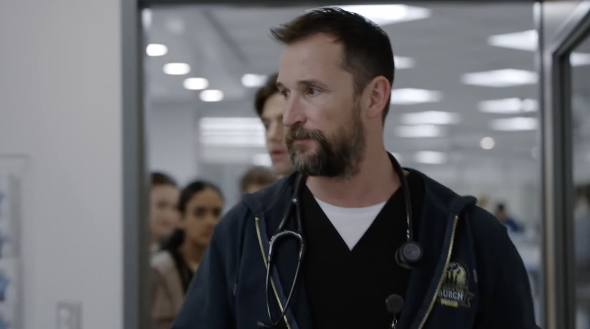 Doctor walking into hospital room with people following behind him