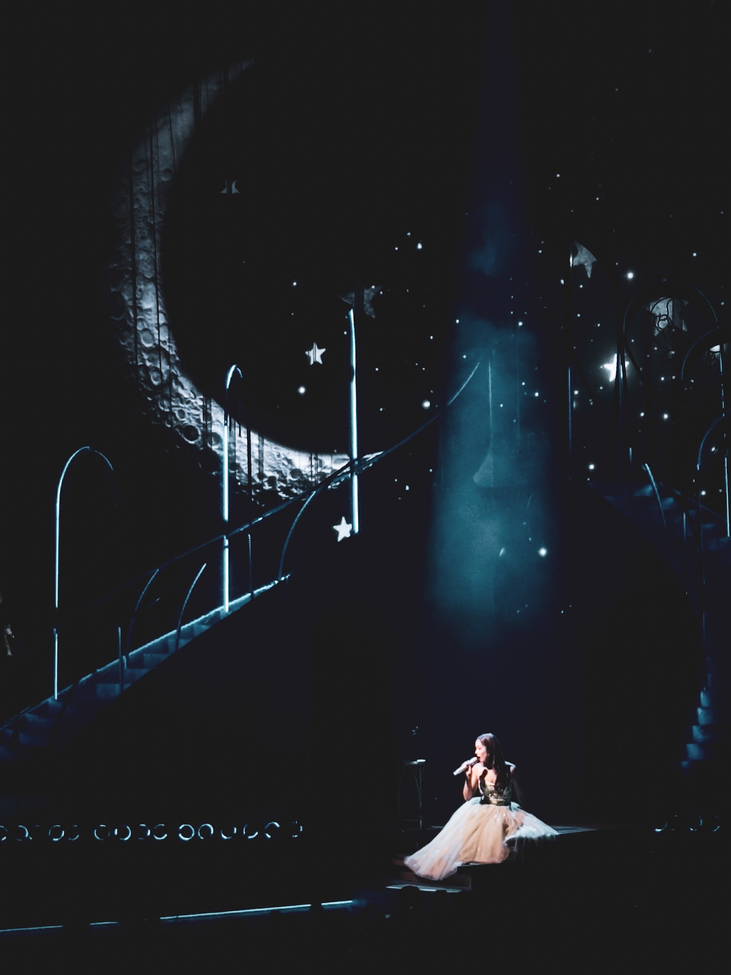 Music artist Laufey sitting on stage and singing.