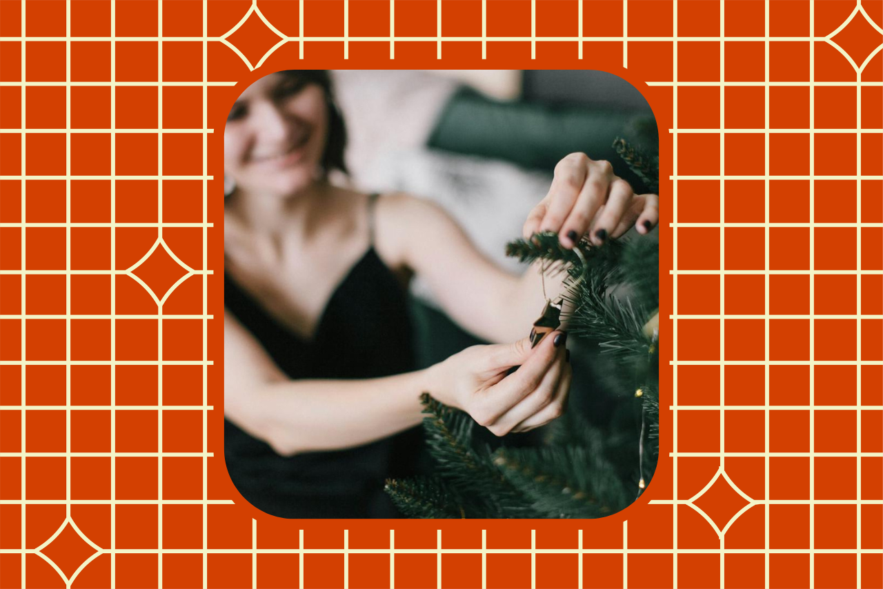 woman putting ornament on christmas tree