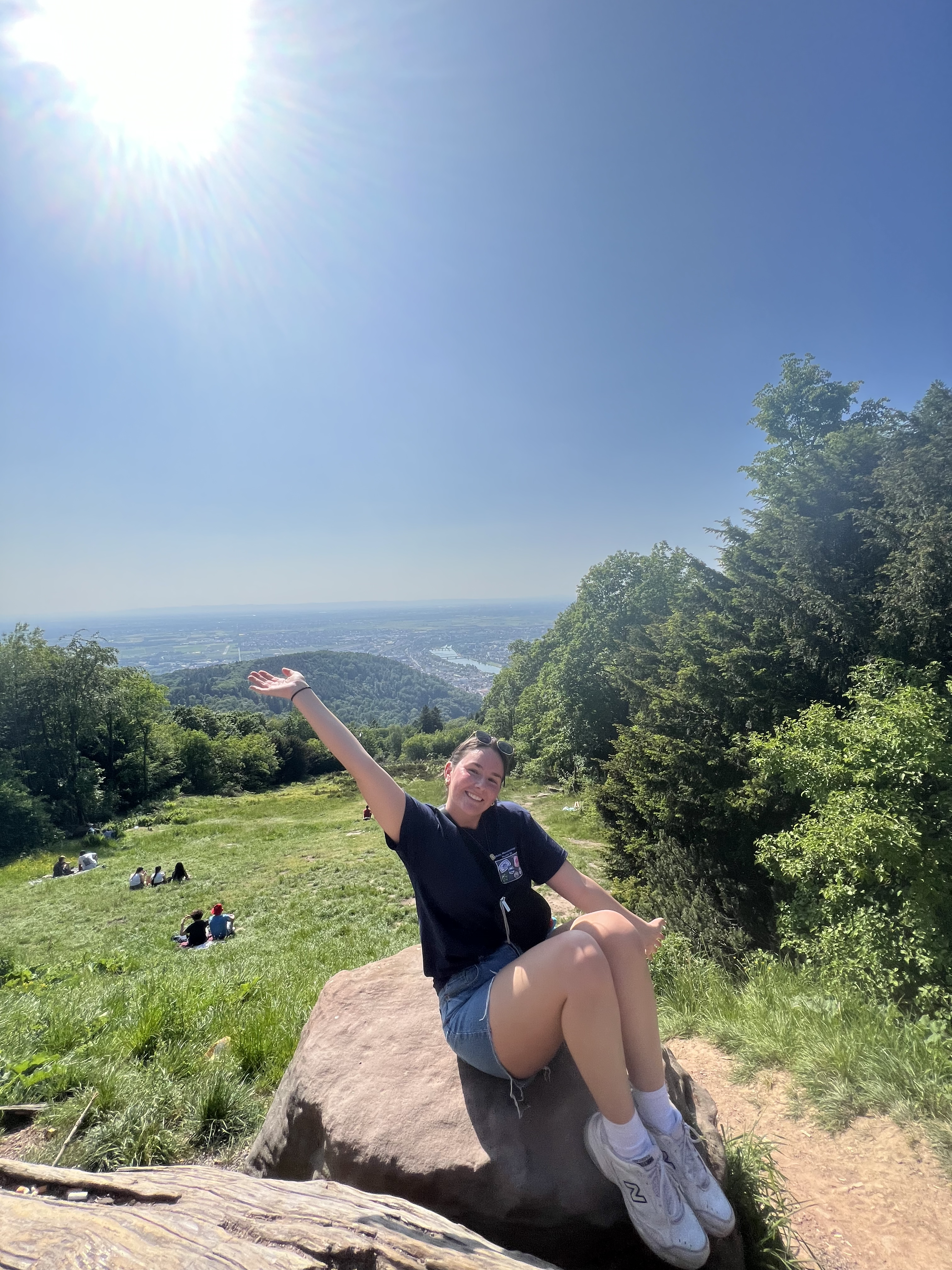 girl sitting on rock in front of city