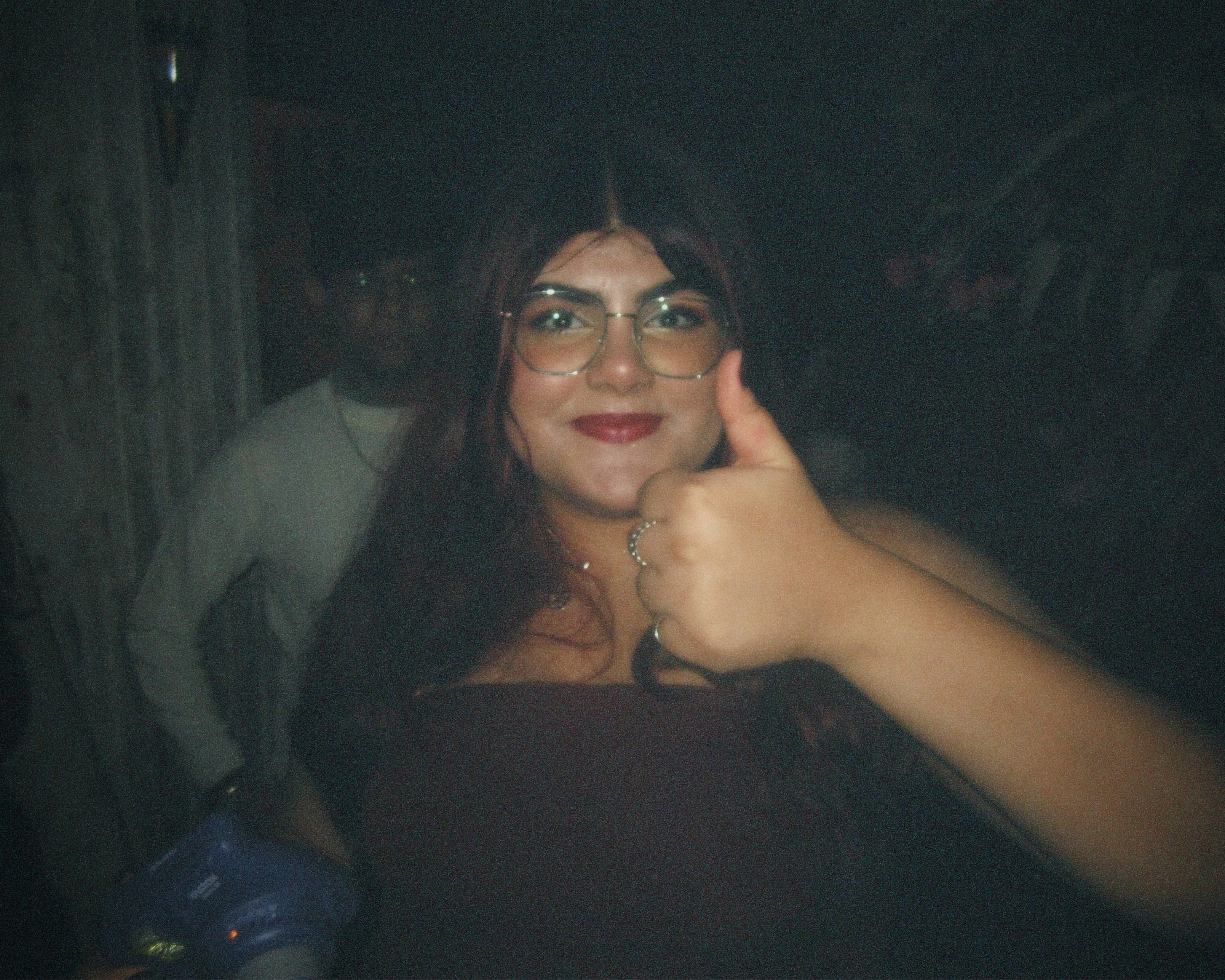 A girl (me) showing thumbs up with Instax Mini polaroid camera in hand.