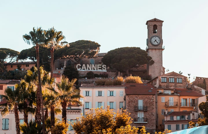 A natural landscape of Cannes in France. There is a clock and trees in the picture too.