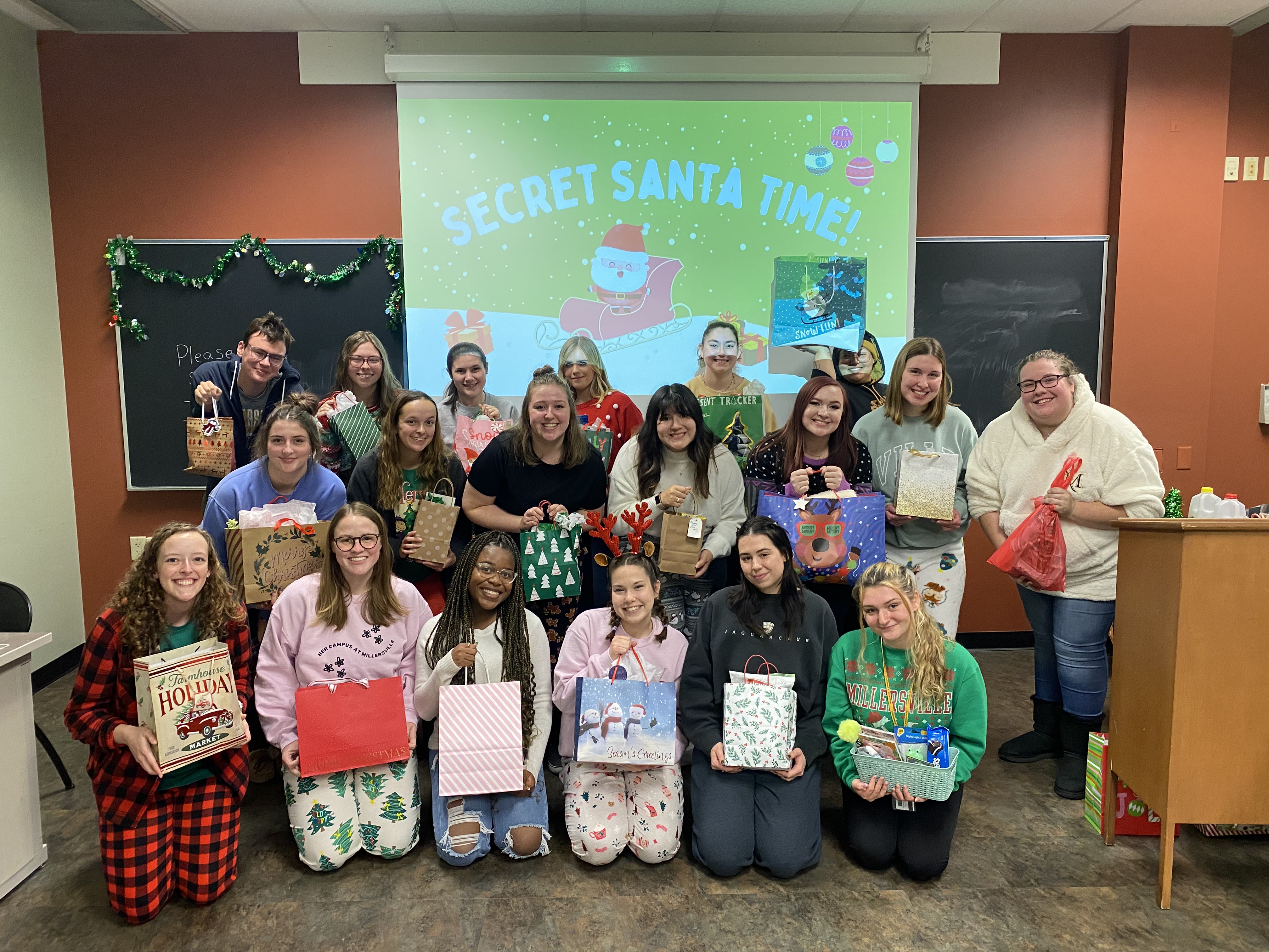 Her Campus Members at holiday party holding presents