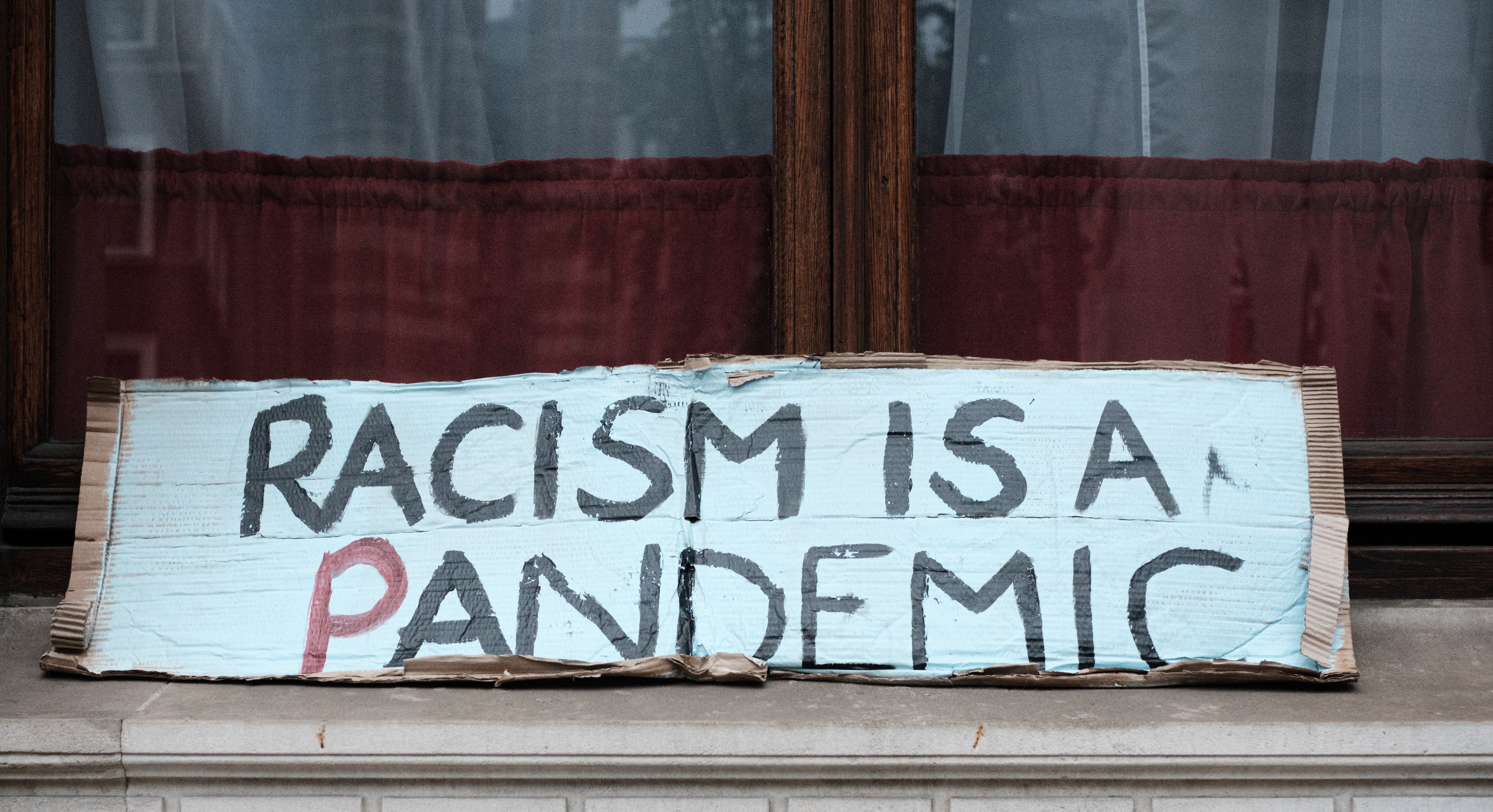racism is a pandemic protest sign by Ehimetalor Akhere Unuabona?width=698&height=466&fit=crop&auto=webp&dpr=4
