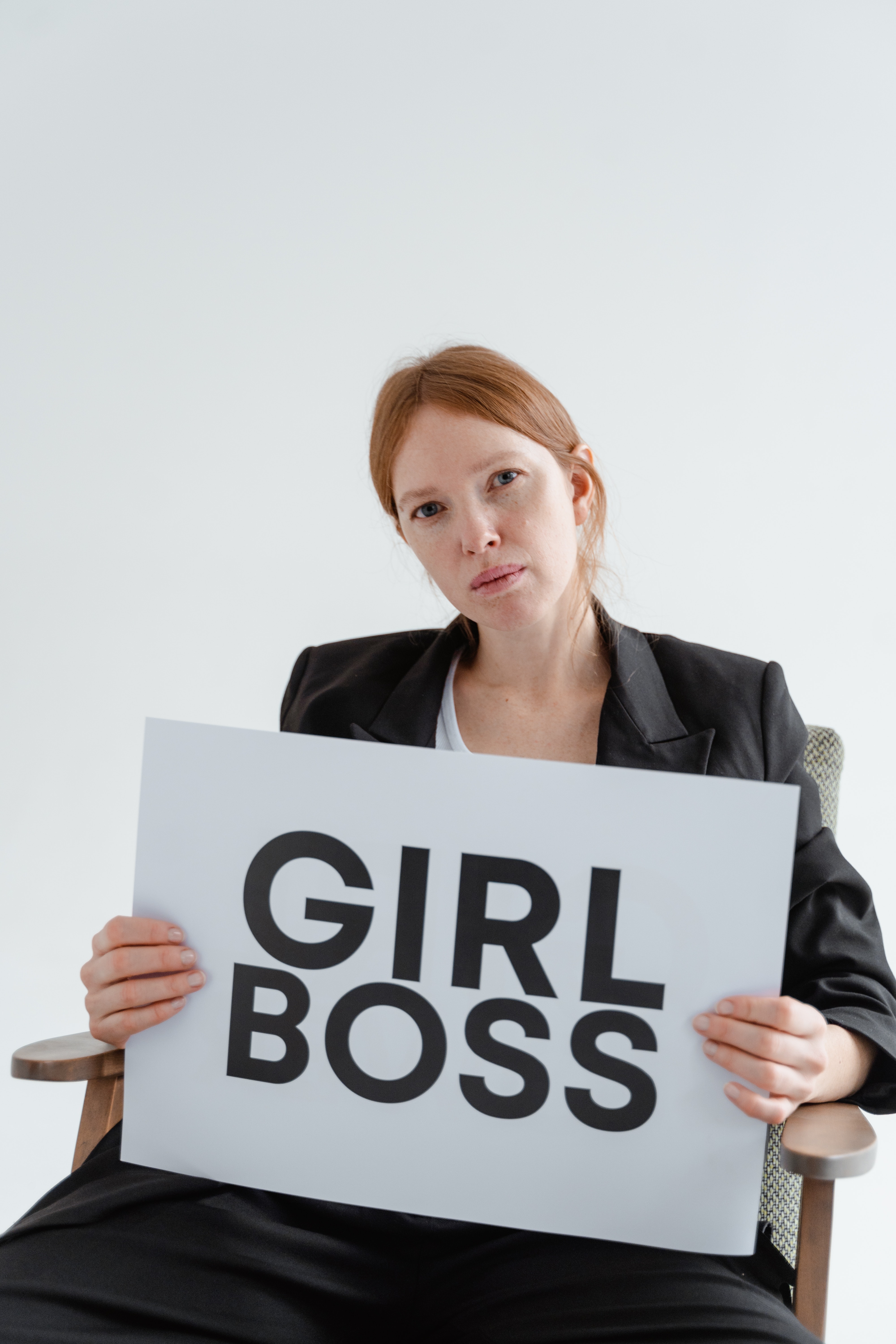 woman holding girlboss sign
