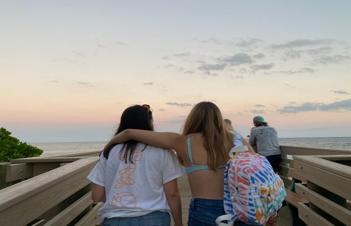 2 girls walking down the beach