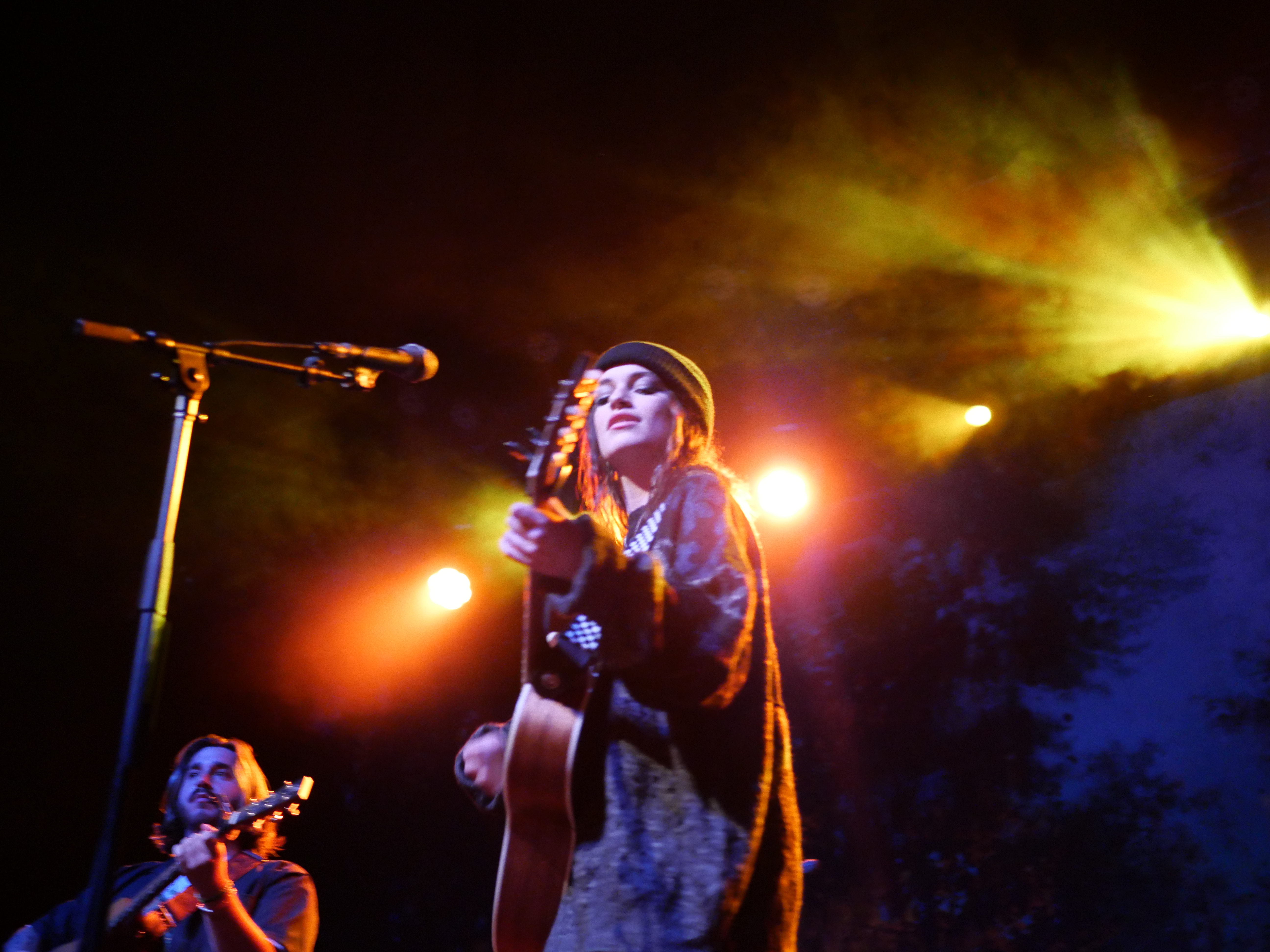 Woman and man playing guitar on stage