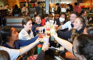 Friends sitting around a table with boba drinks