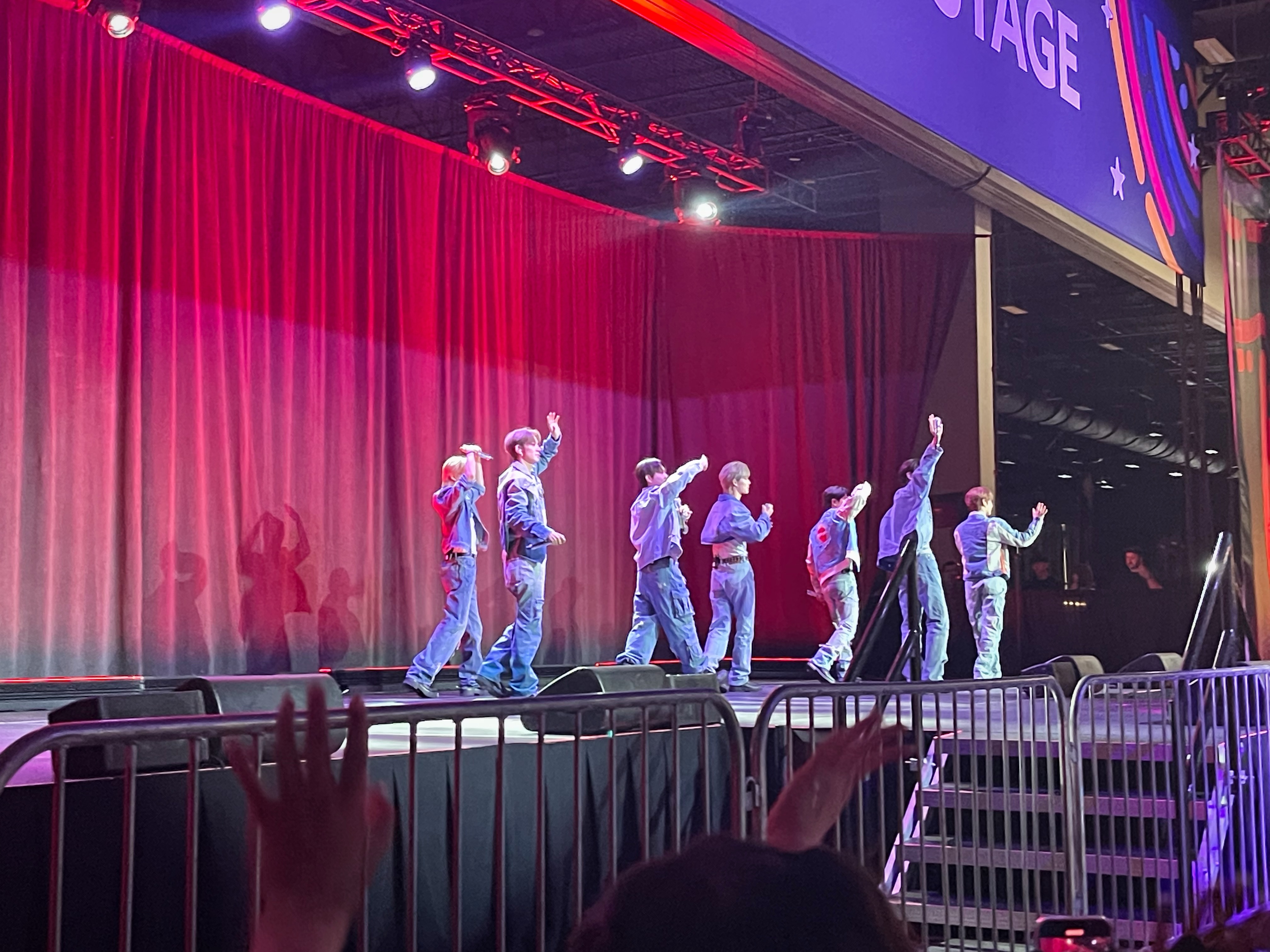 k-pop group on stage saying goodbye to fans