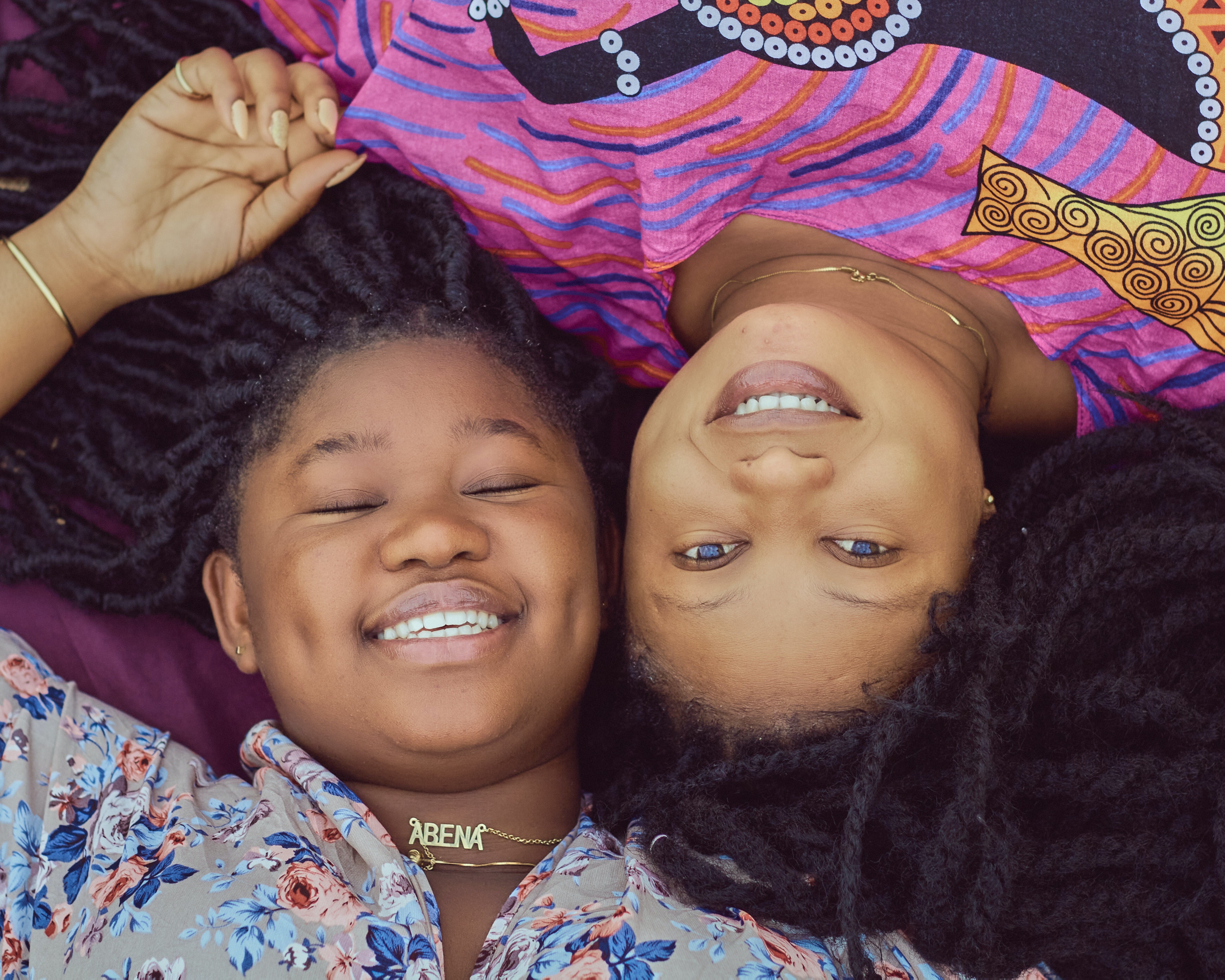 Two people smiling, one wearing nameplate necklace
