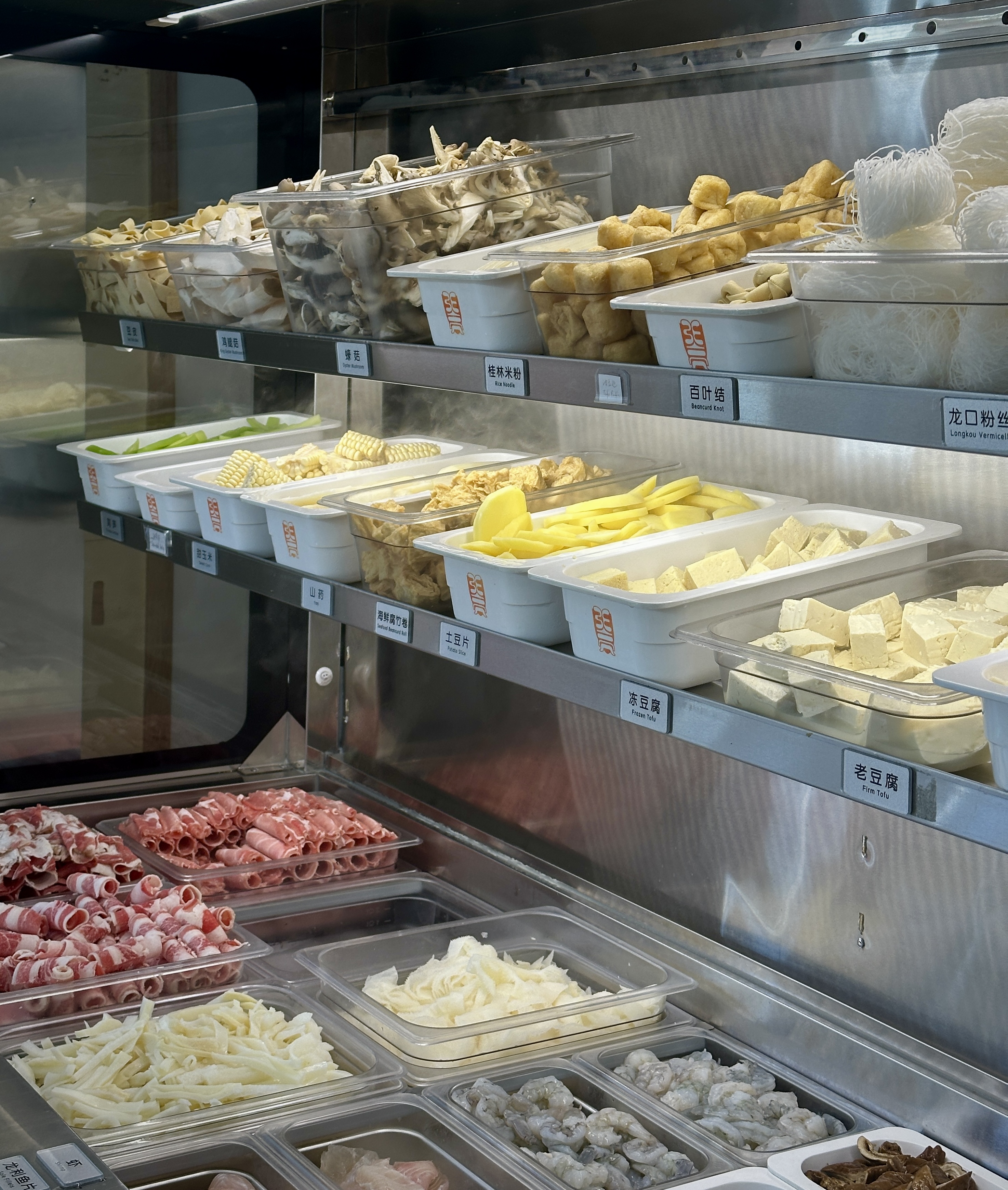 Ingredients available for malatang including meats, noodles, and tofu