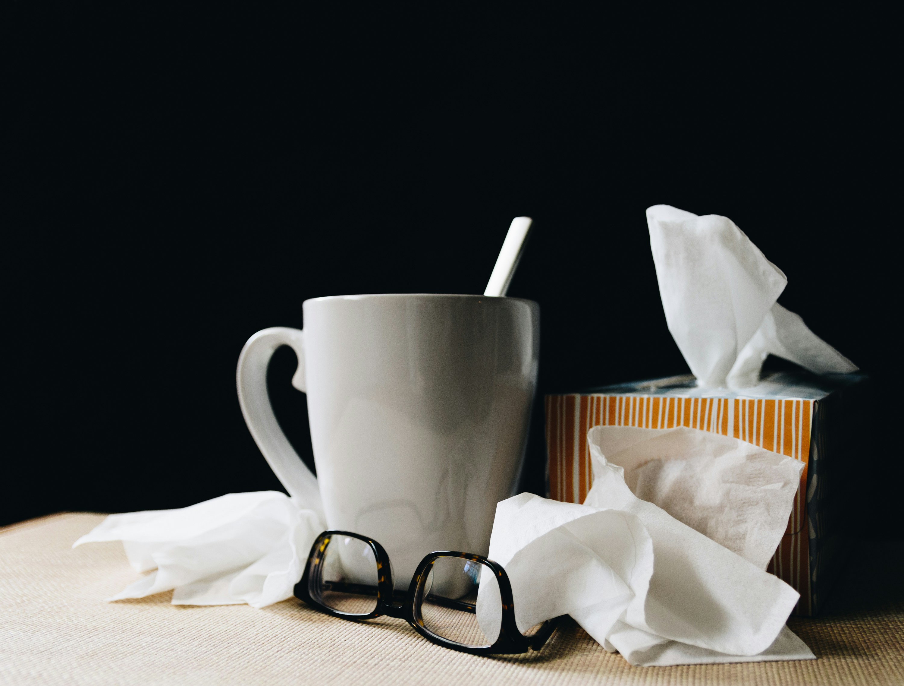 Tissues along with glasses, and a coffee mug.