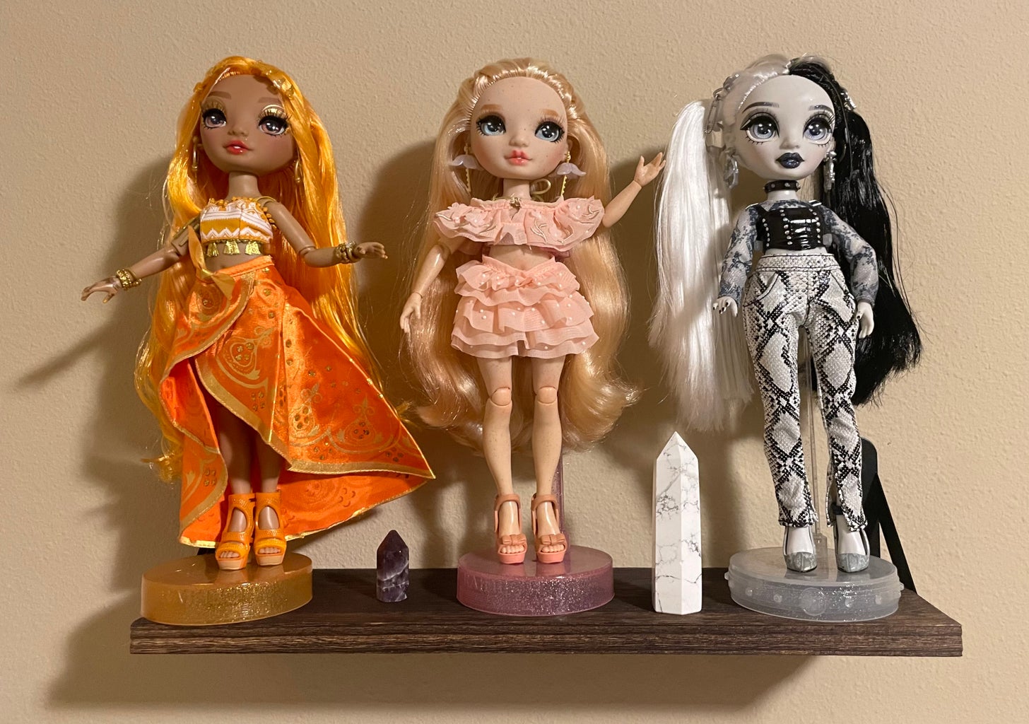 A shelf of Rainbow High and Shadow High dolls