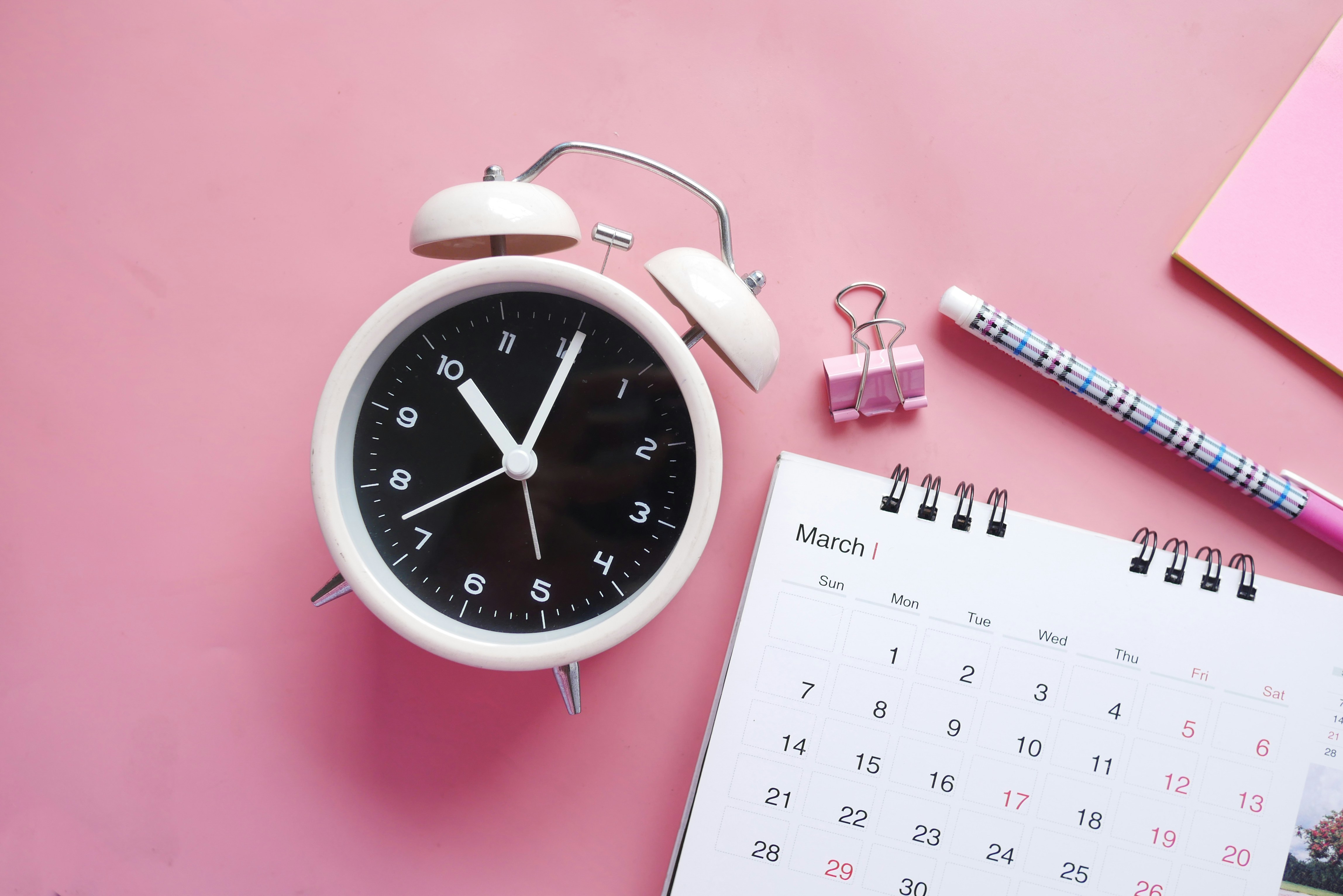 white clock with calendar and pink background